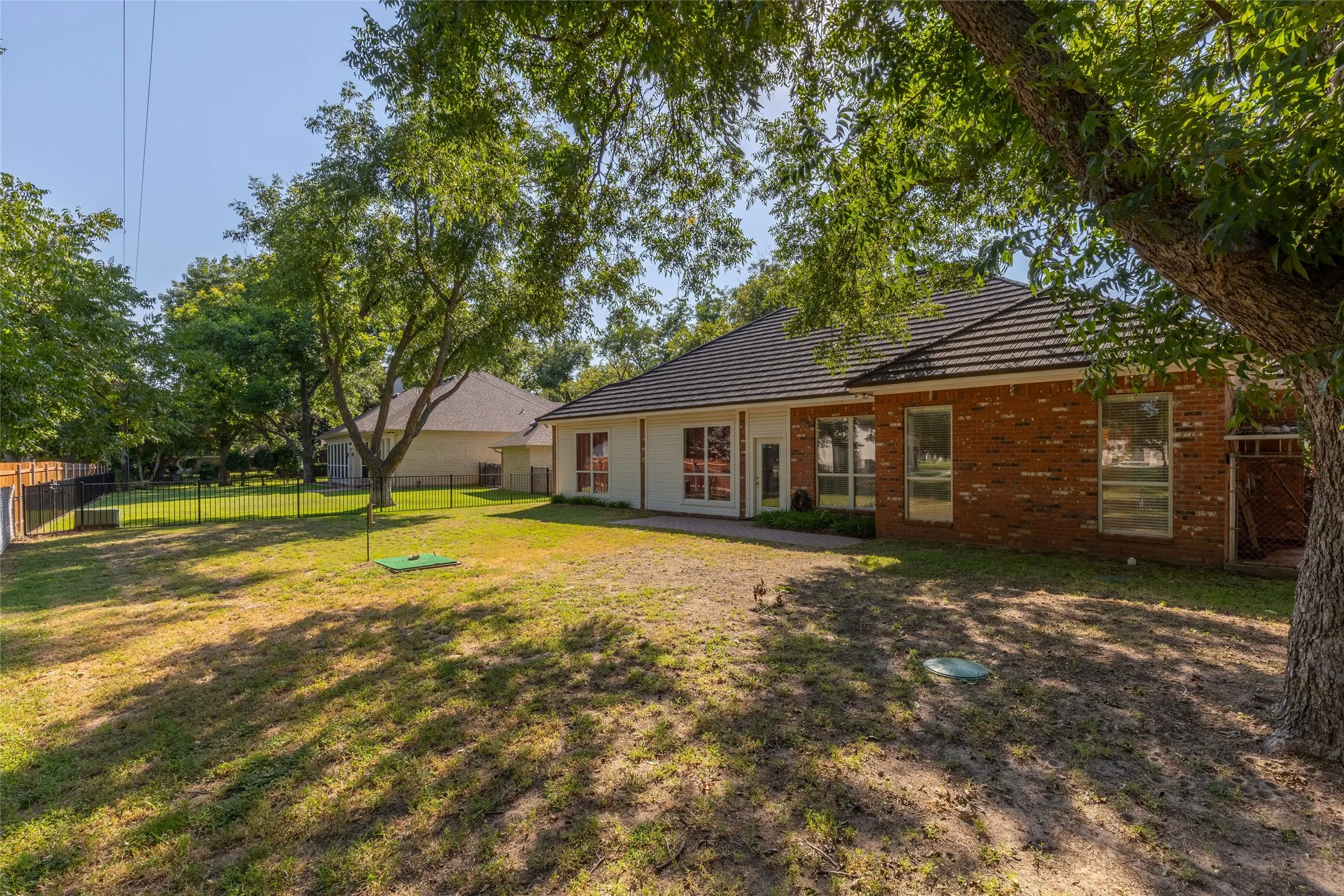 Back of property featuring brick siding and a fenced backyard