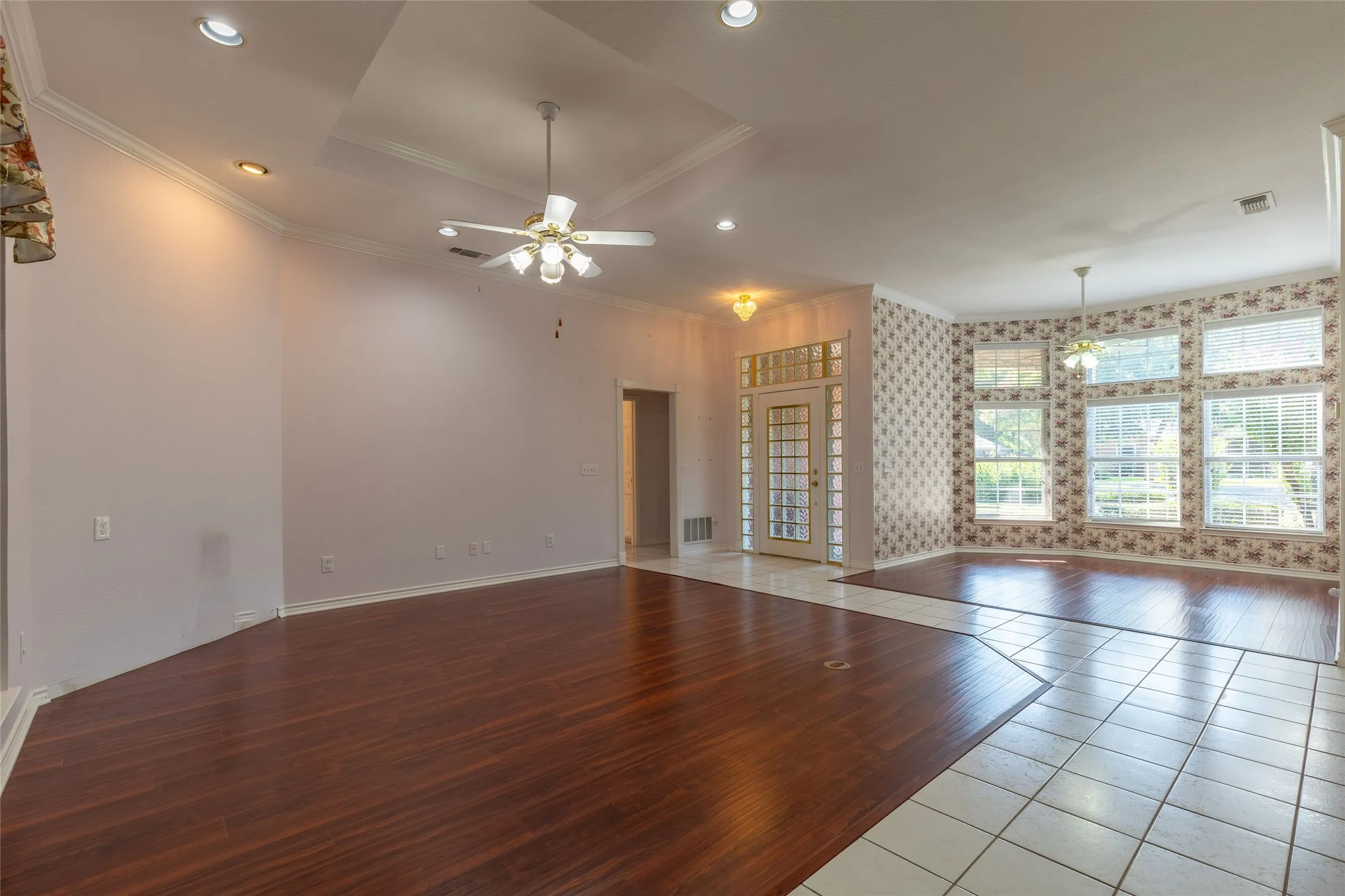 Unfurnished living room with wood finished floors, crown molding, recessed lighting, ceiling fan, and coffered ceiling