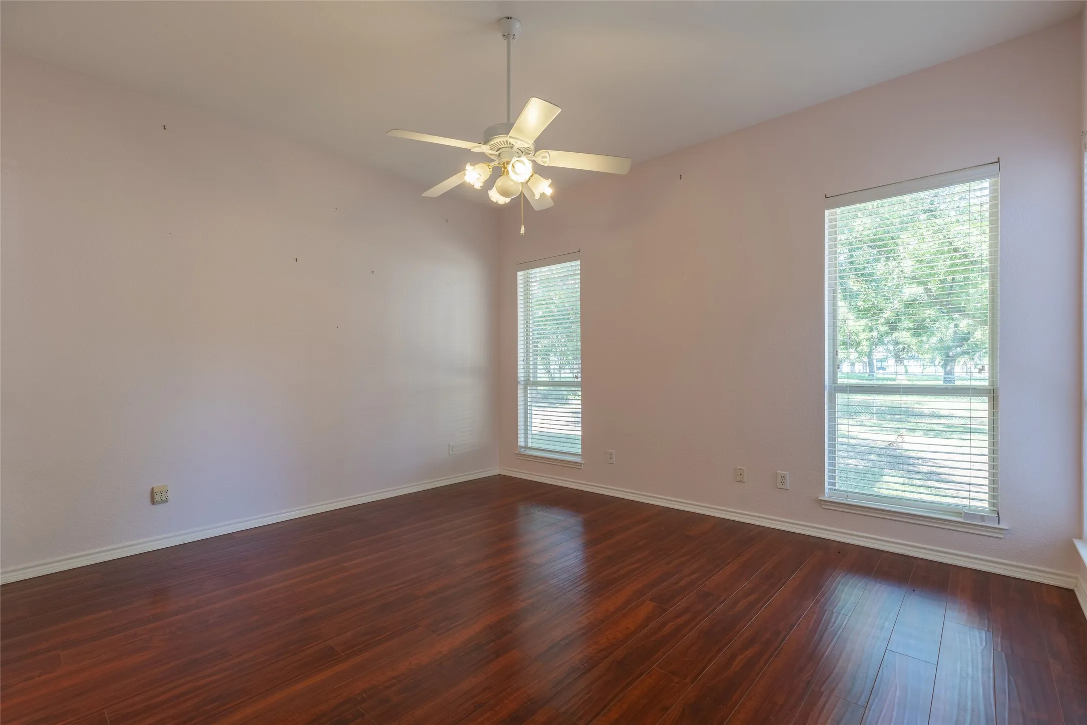 Spare room with dark wood finished floors and ceiling fan