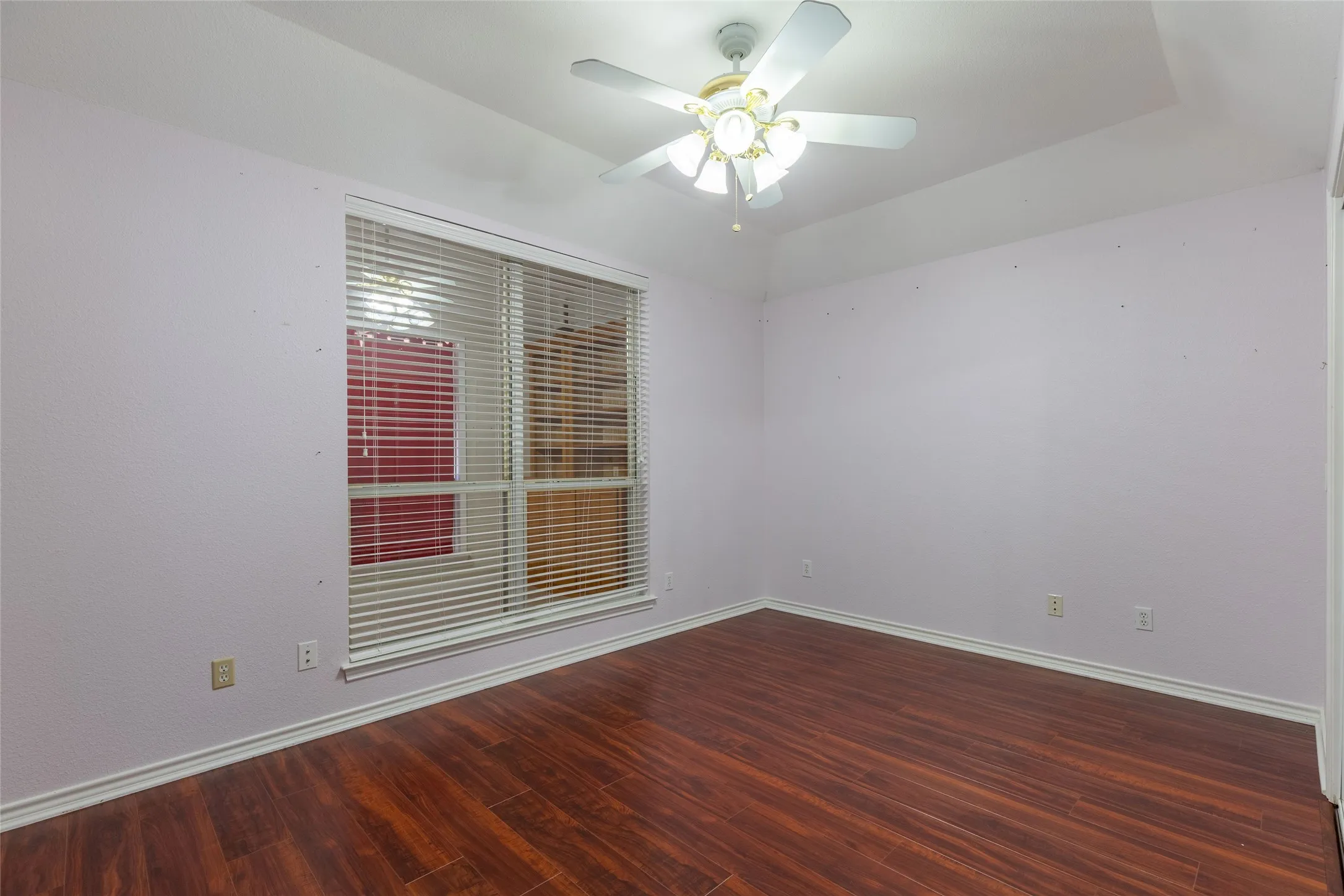 Empty room featuring wood finished floors and a ceiling fan