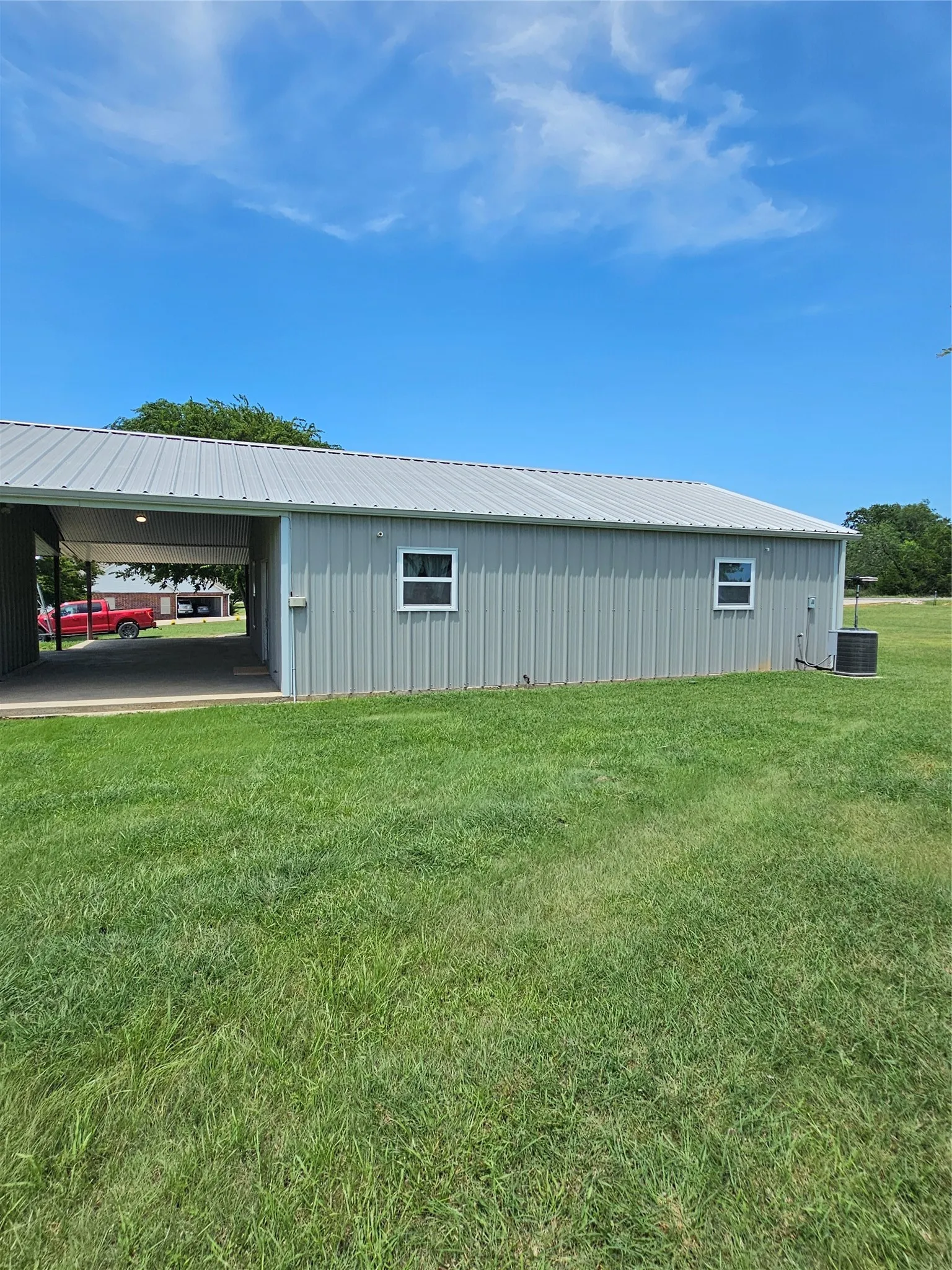 View of home's exterior featuring a lawn, a metal roof.