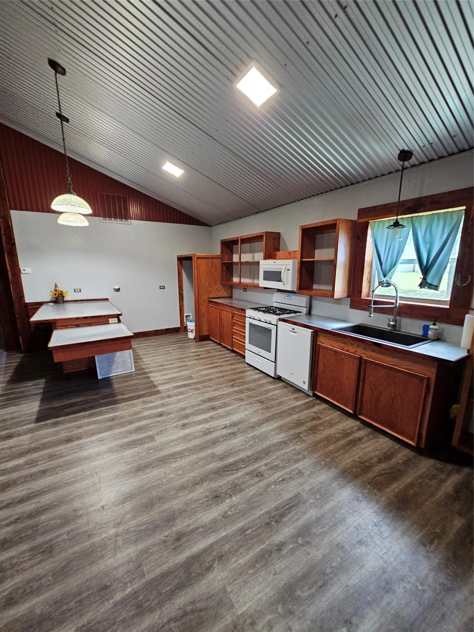 Kitchen featuring vaulted ceiling, open shelves, white range, dark wood-style flooring, and brown cabinetry