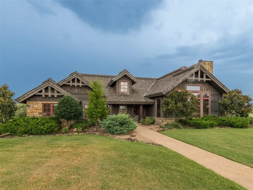 Craftsman house featuring a front lawn, stone siding, and a chimney