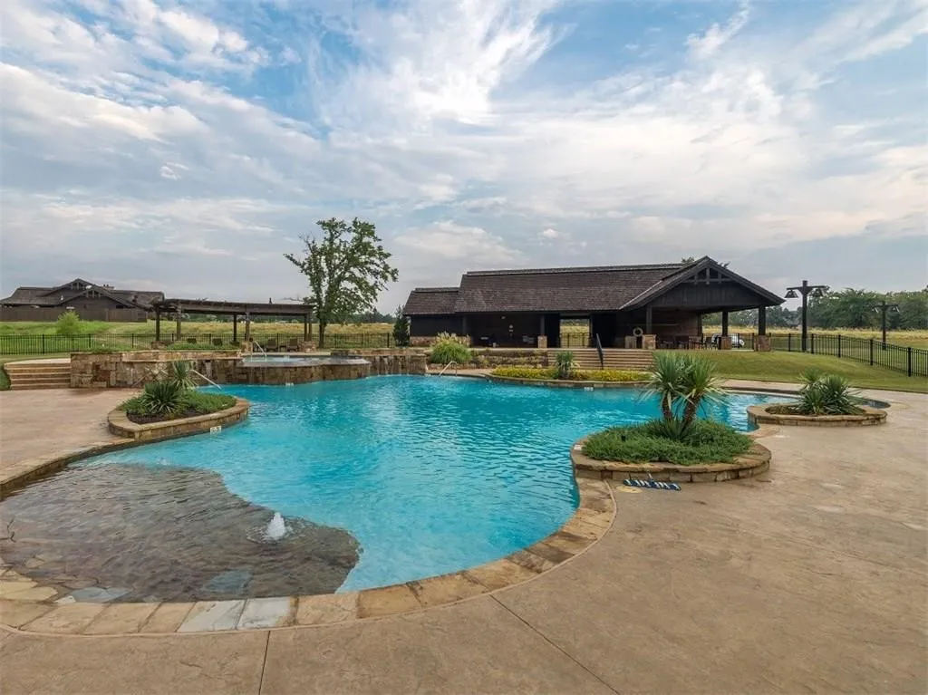 Community pool featuring an in-ground hot tub, a gazebo, and a patio area