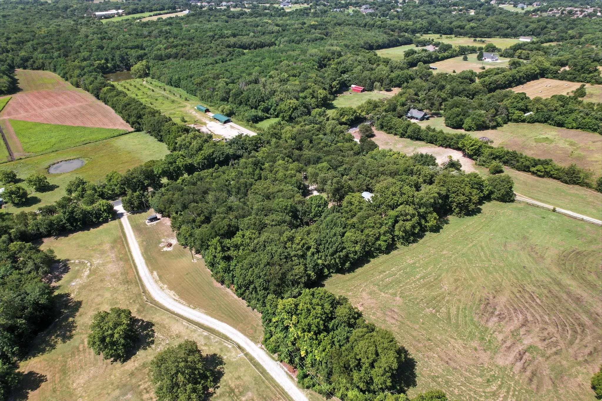 Aerial overview of property's location with rural landscape and a heavily wooded area