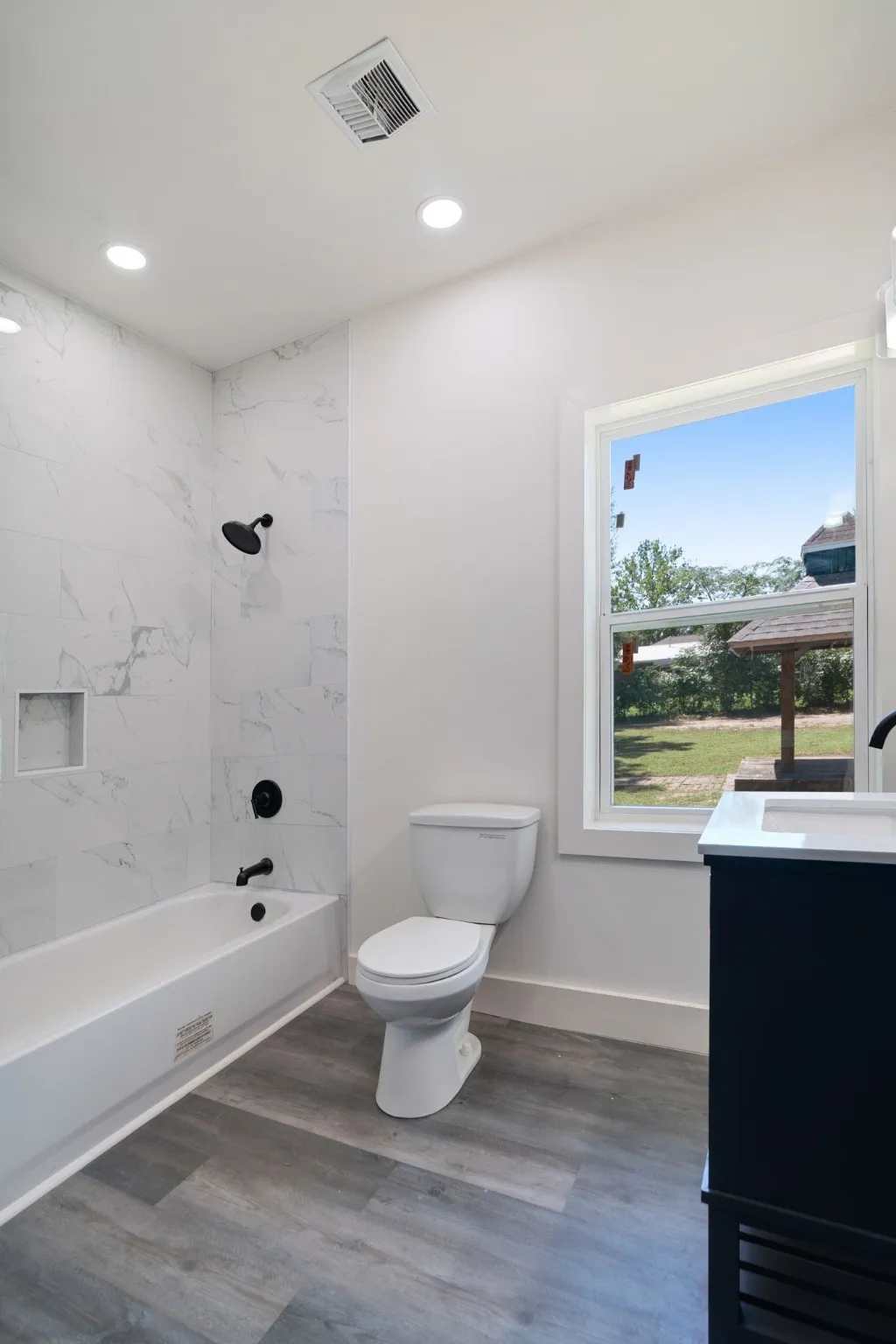 Full bathroom with wood finished floors, vanity, shower / washtub combination, and recessed lighting