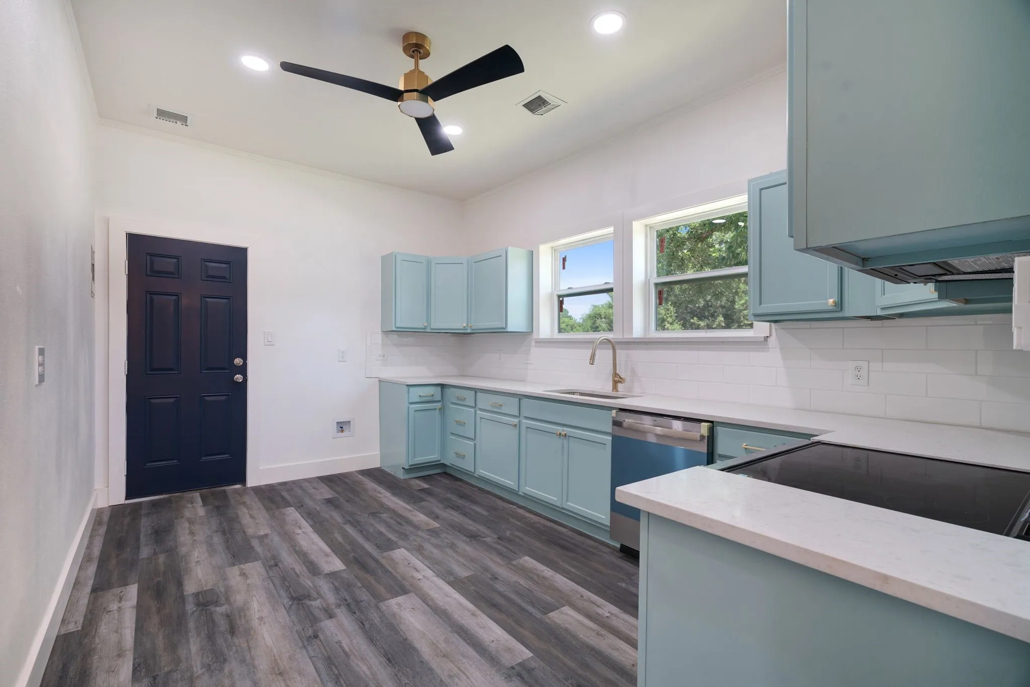 Kitchen with ceiling fan, crown molding, blue cabinets, backsplash, range, and dishwasher