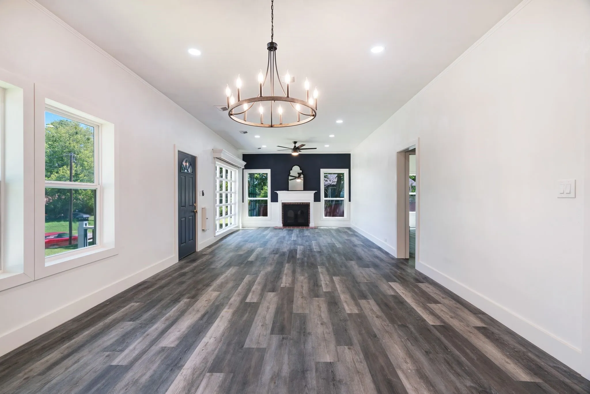 living room with a chandelier, dark wood-style floors, a fireplace, recessed lighting, and ornamental molding