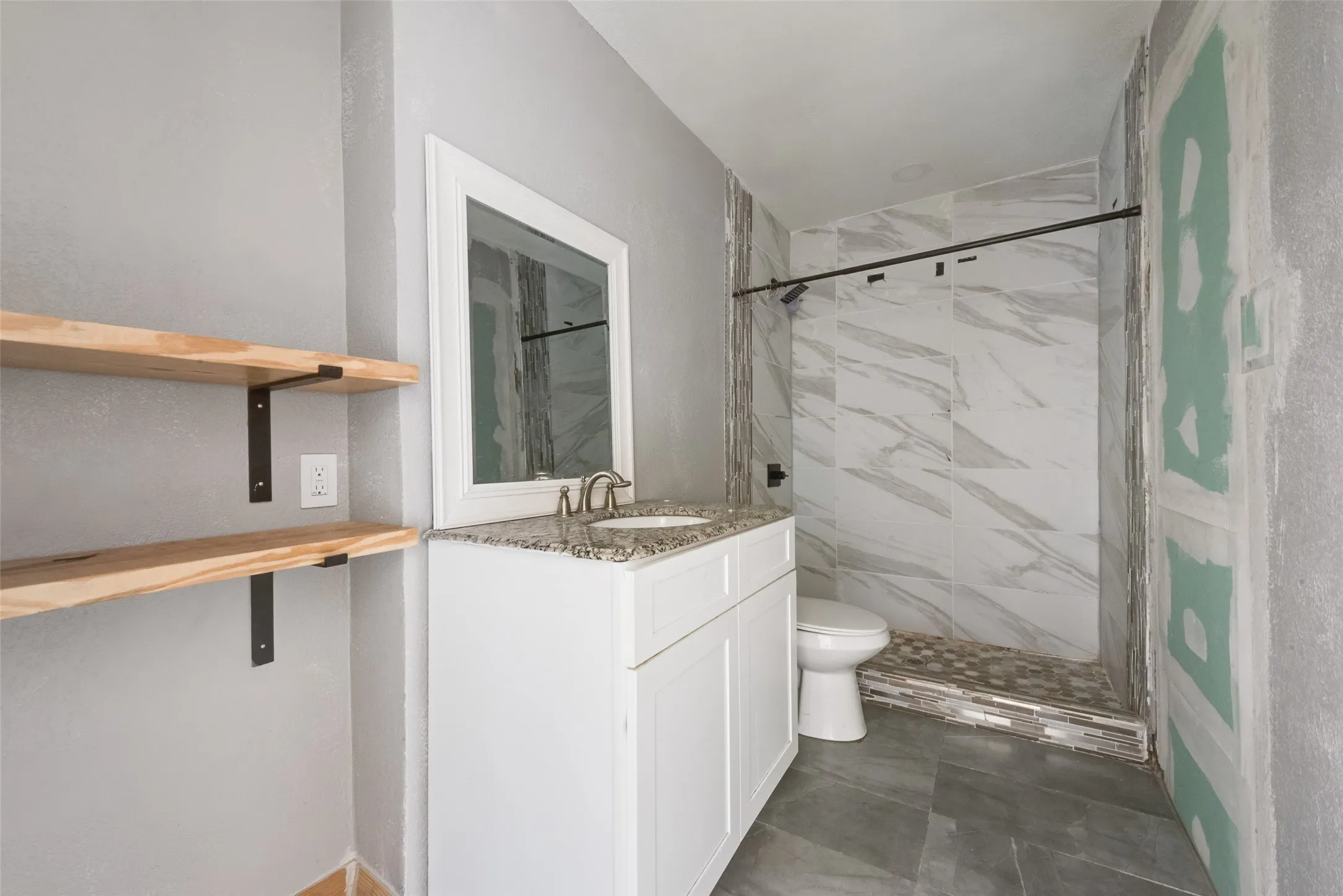 Full bathroom with a marble finish shower and vanity