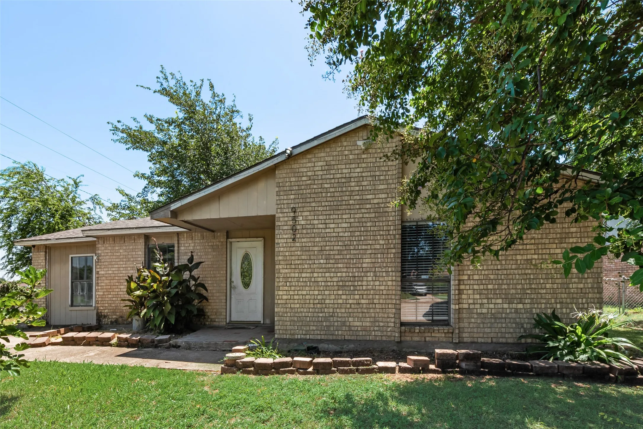 View of front of property with brick siding and a front yard