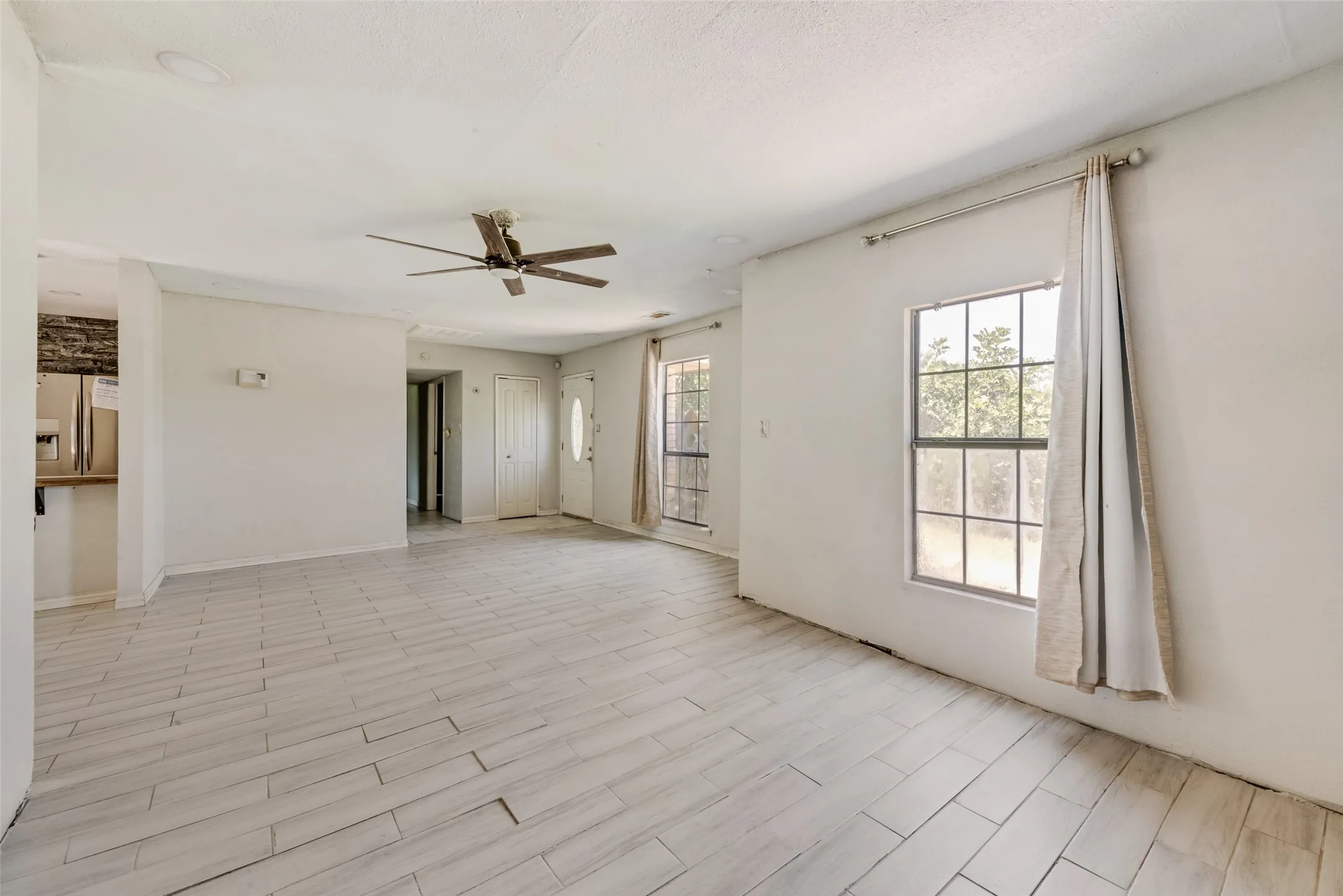 Unfurnished room featuring a ceiling fan and baseboards