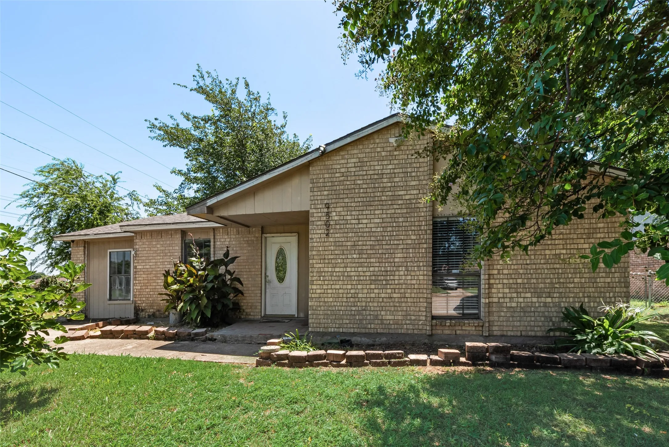 View of front of house featuring a front lawn and brick siding