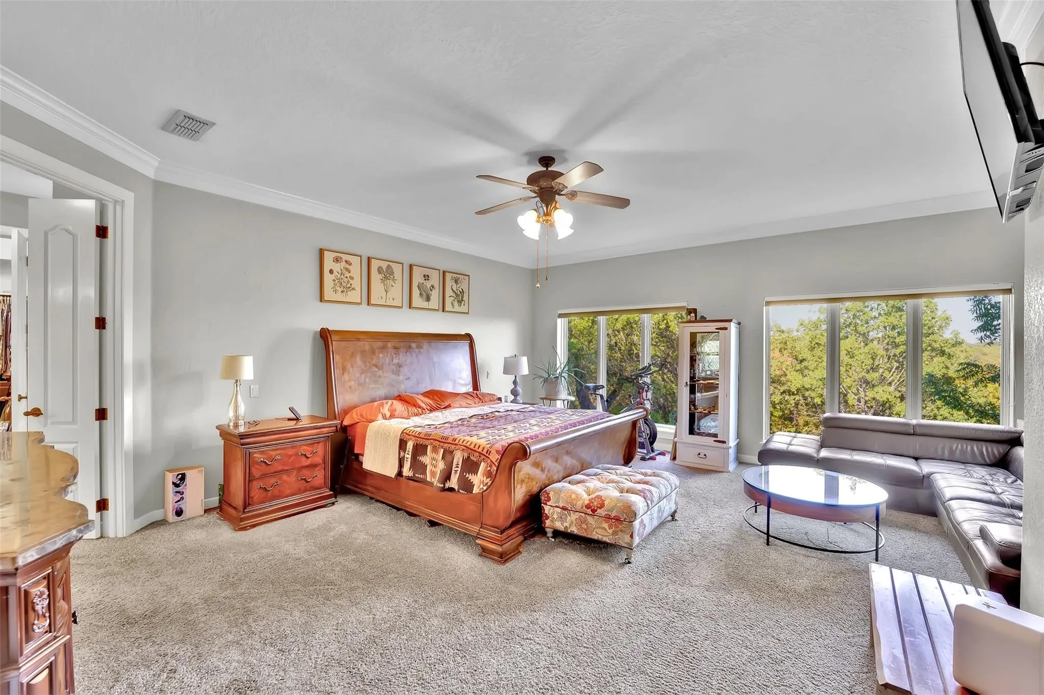 Carpeted bedroom featuring ornamental molding and a ceiling fan