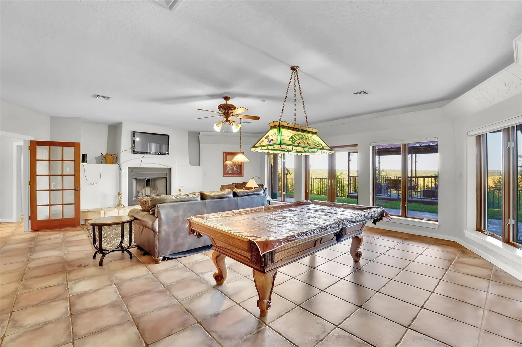 Recreation room featuring billiards, a ceiling fan, a fireplace, and light tile patterned floors