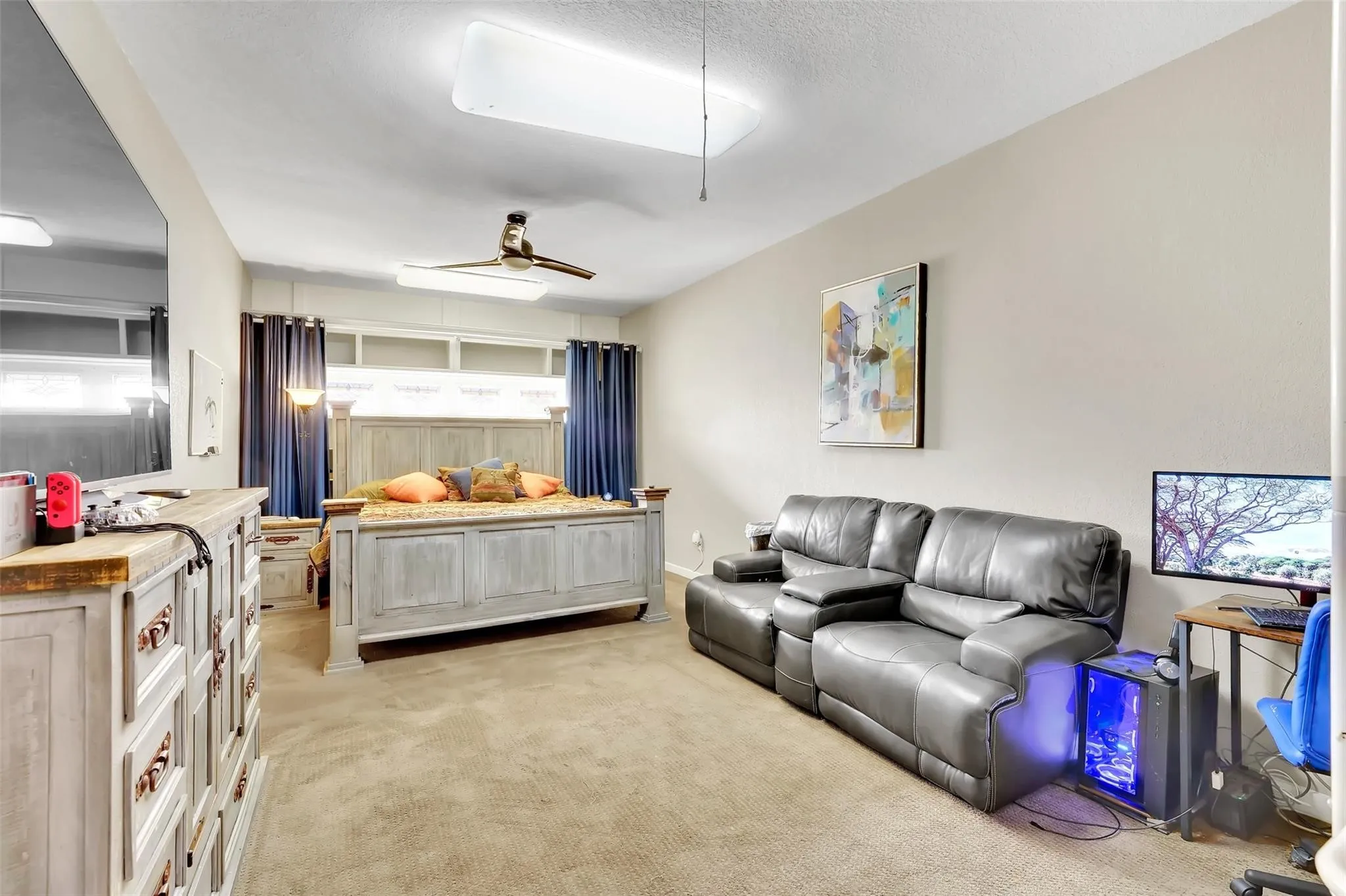 Bedroom with light colored carpet and a ceiling fan