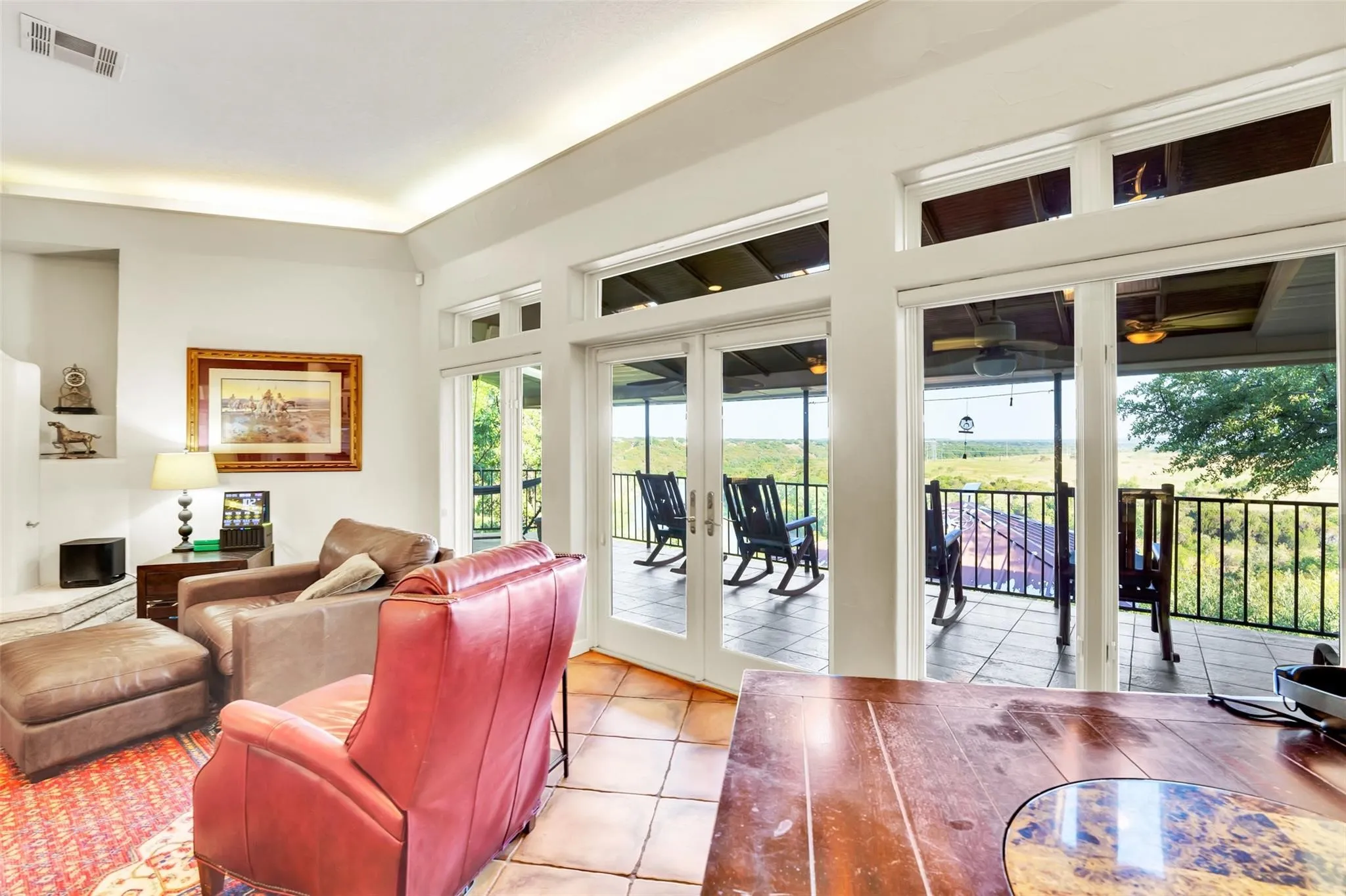 Living area with french doors, healthy amount of natural light, light tile patterned floors, and a ceiling fan