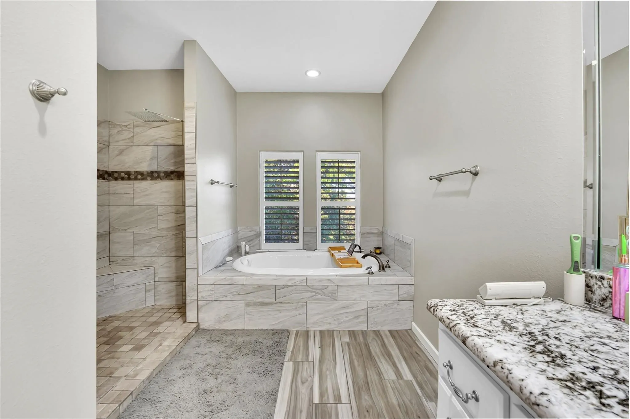 Bathroom with vanity, a garden tub, walk in shower, recessed lighting, and wood finished floors