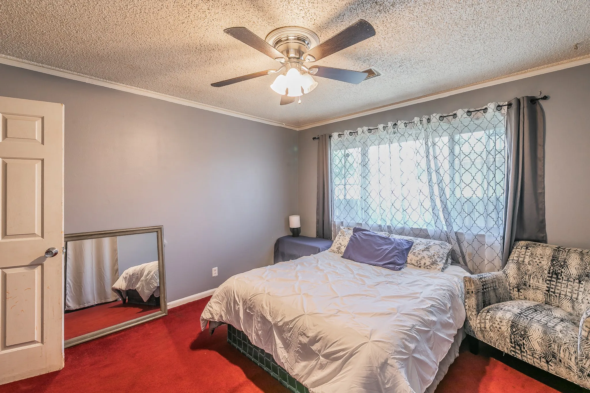 Carpeted bedroom with crown molding, a textured ceiling, and ceiling fan