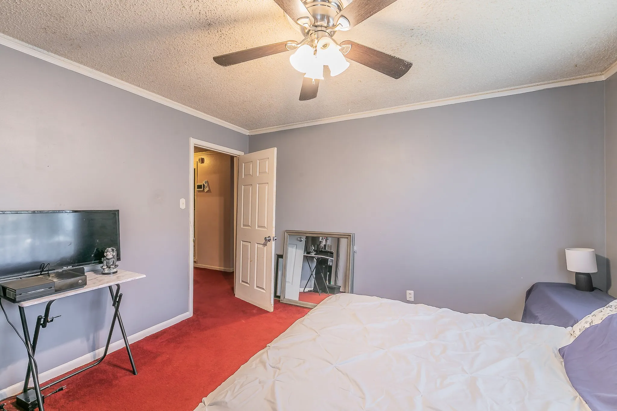 Bedroom featuring carpet flooring, ornamental molding, a textured ceiling, and ceiling fan