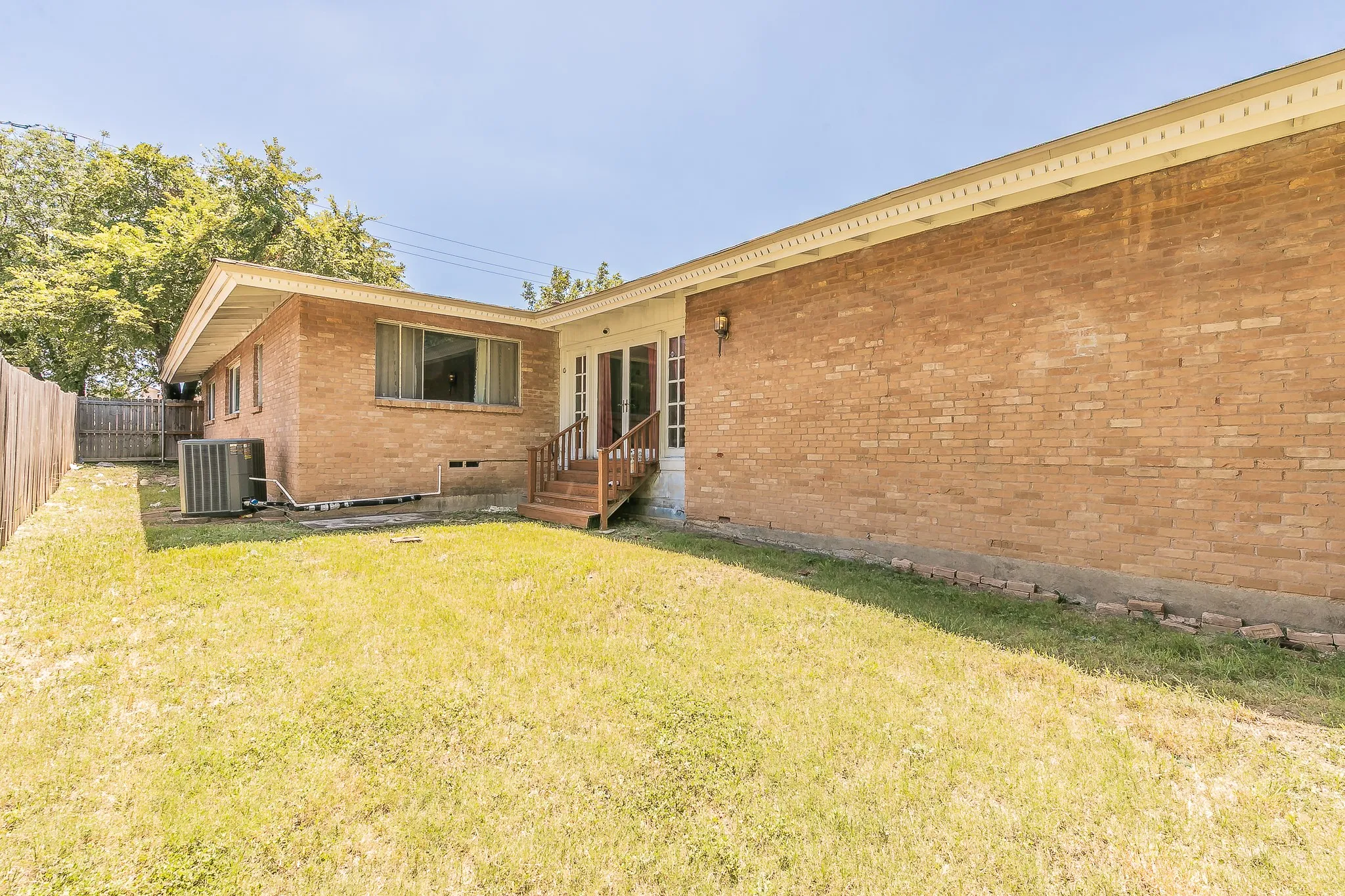Rear view of house featuring brick siding and crawl space