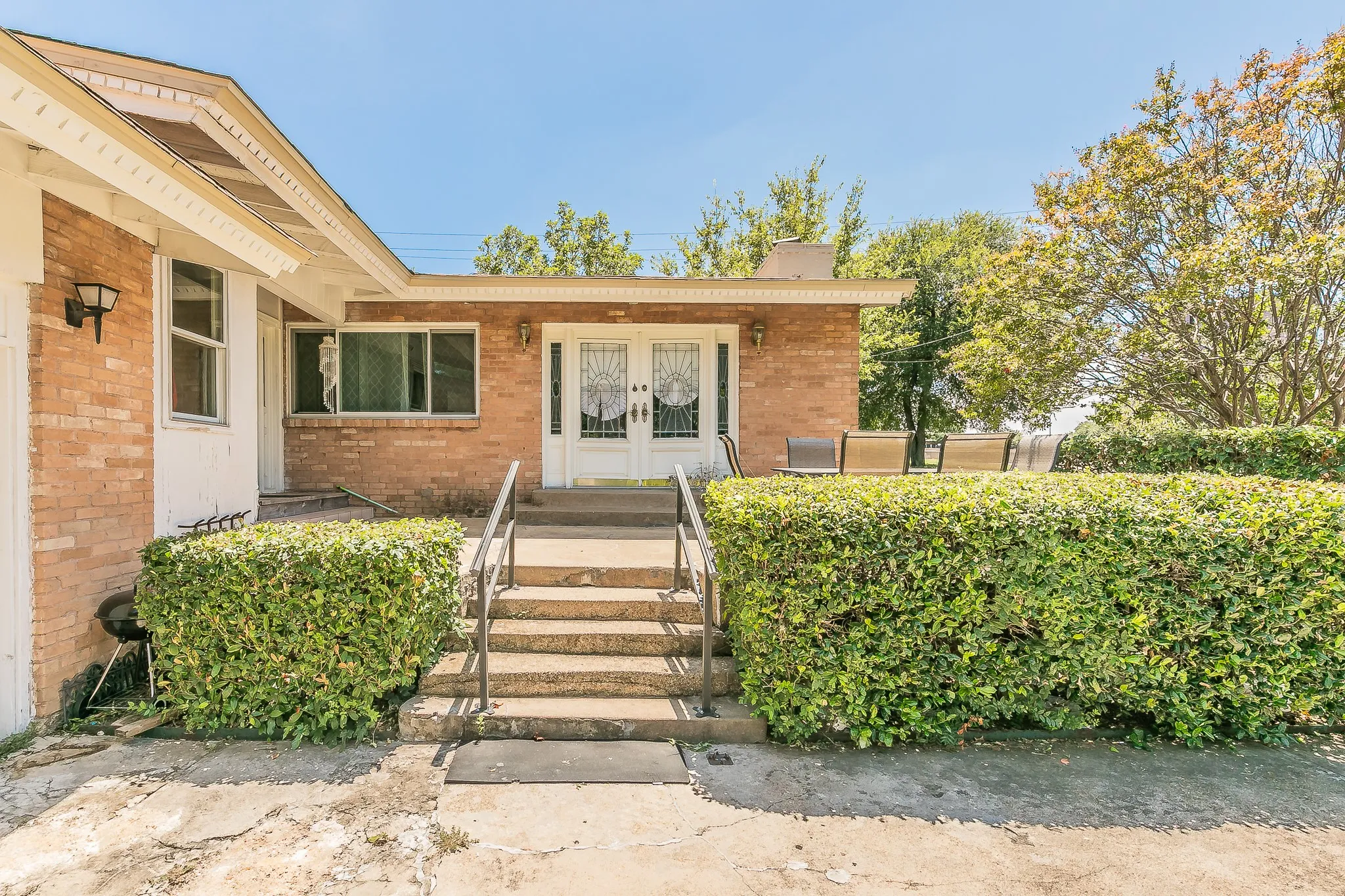 Doorway to property with french doors, brick siding, and a chimney
