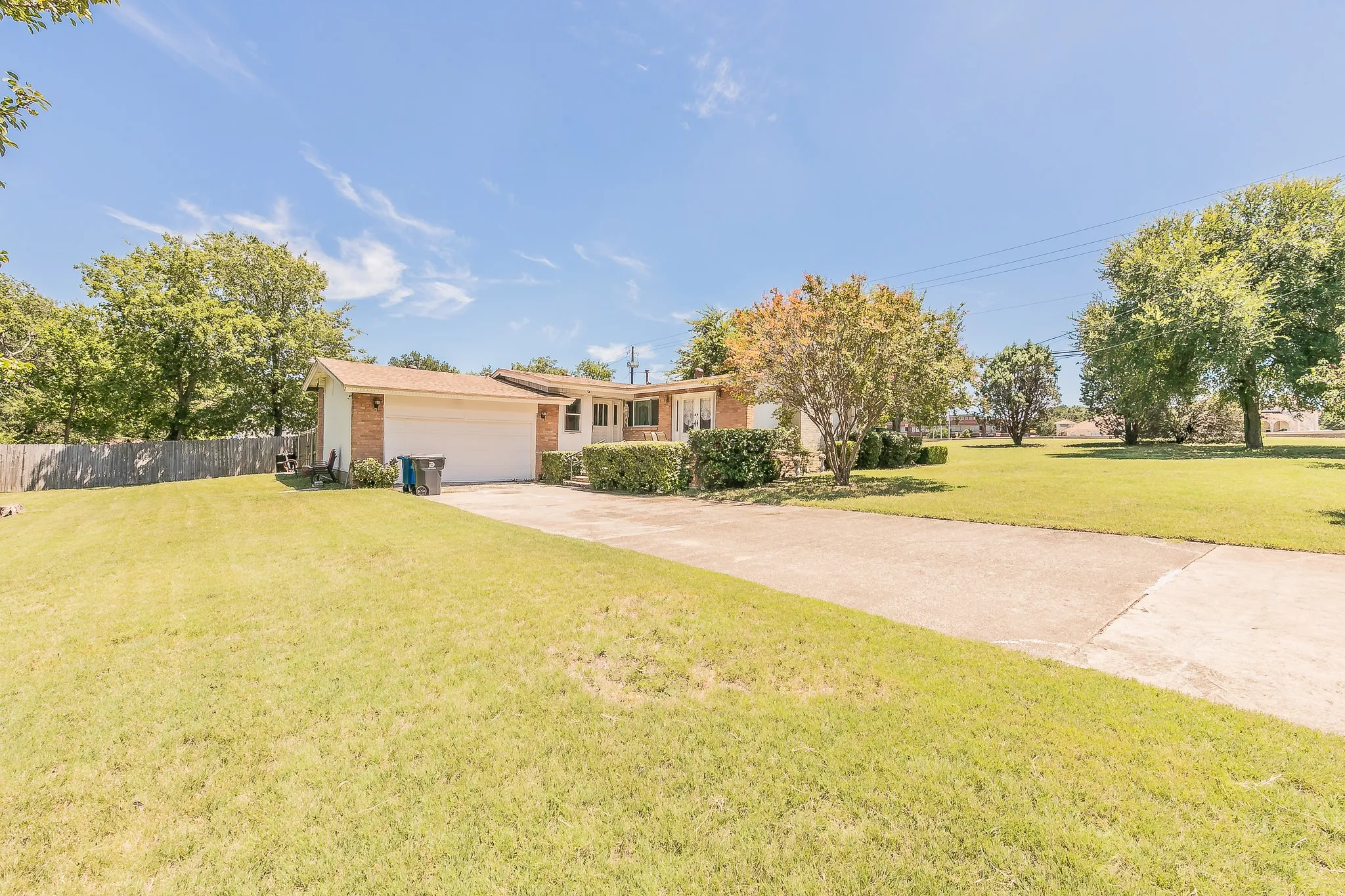 Ranch-style house featuring driveway, an attached garage, and brick siding