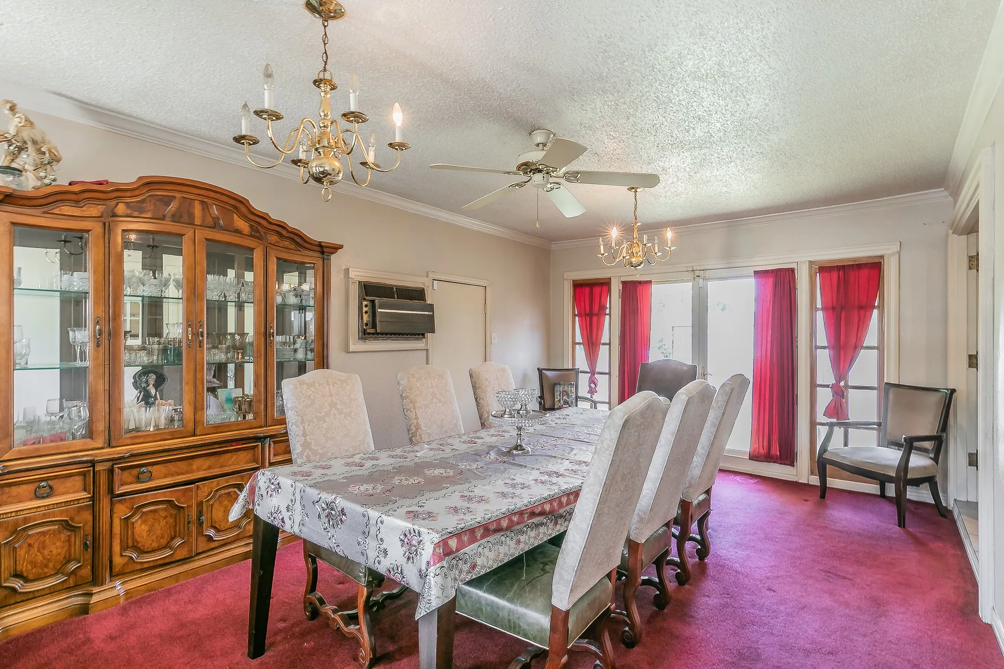 Dining space with a chandelier, dark carpet, a textured ceiling, ceiling fan, and crown molding