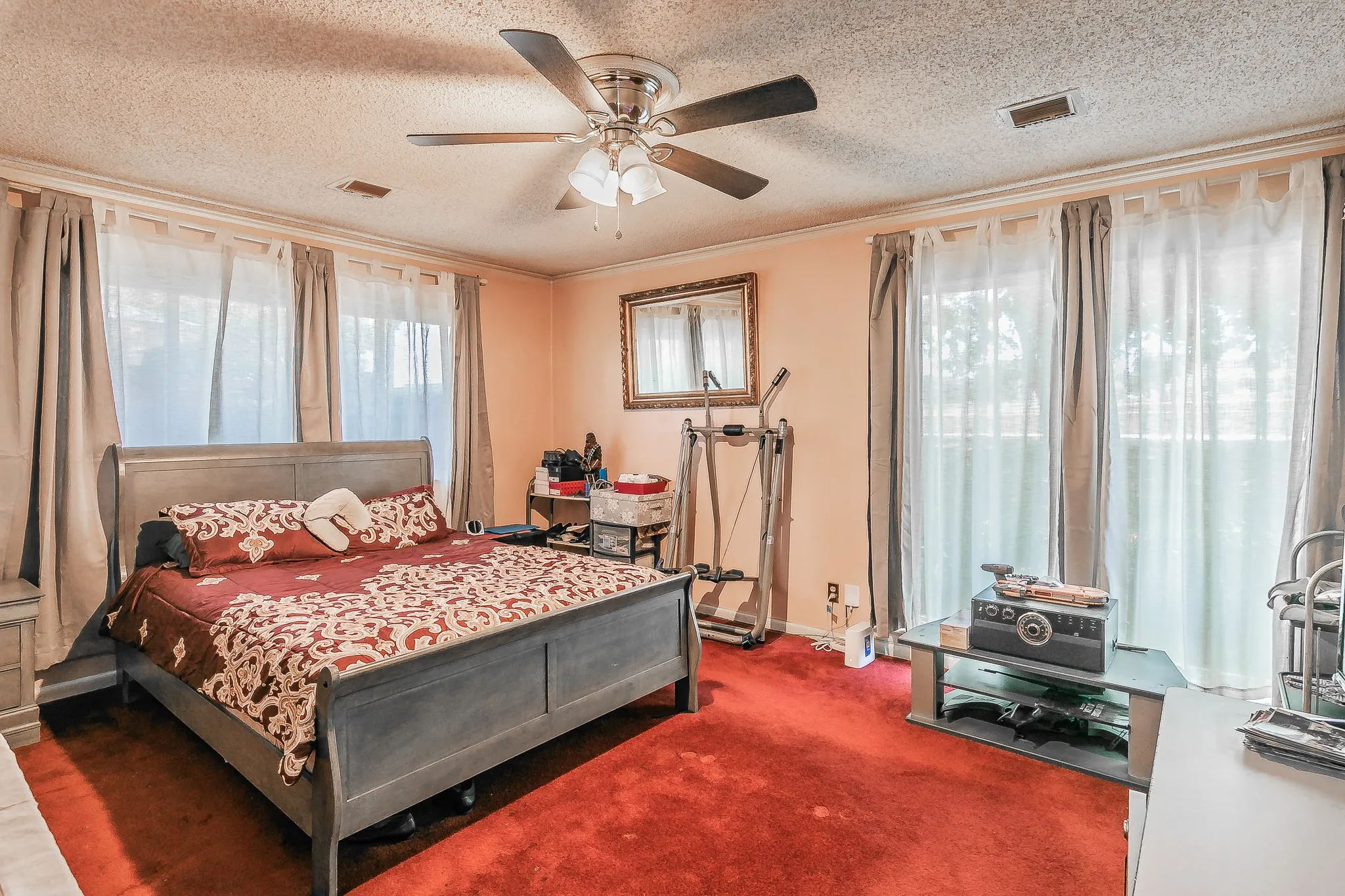Carpeted bedroom featuring crown molding, a textured ceiling, and ceiling fan