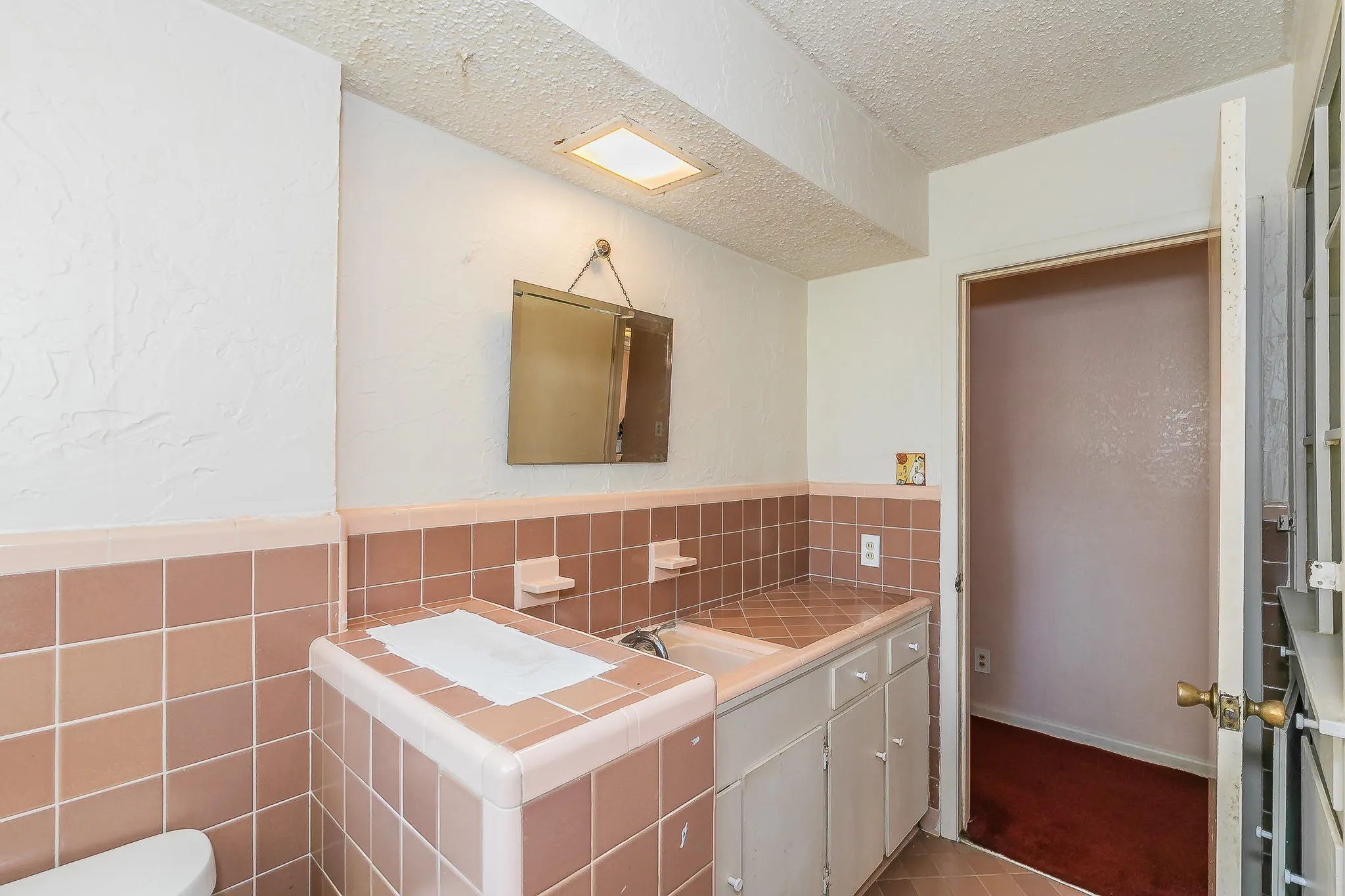 Bathroom with a textured ceiling and vanity
