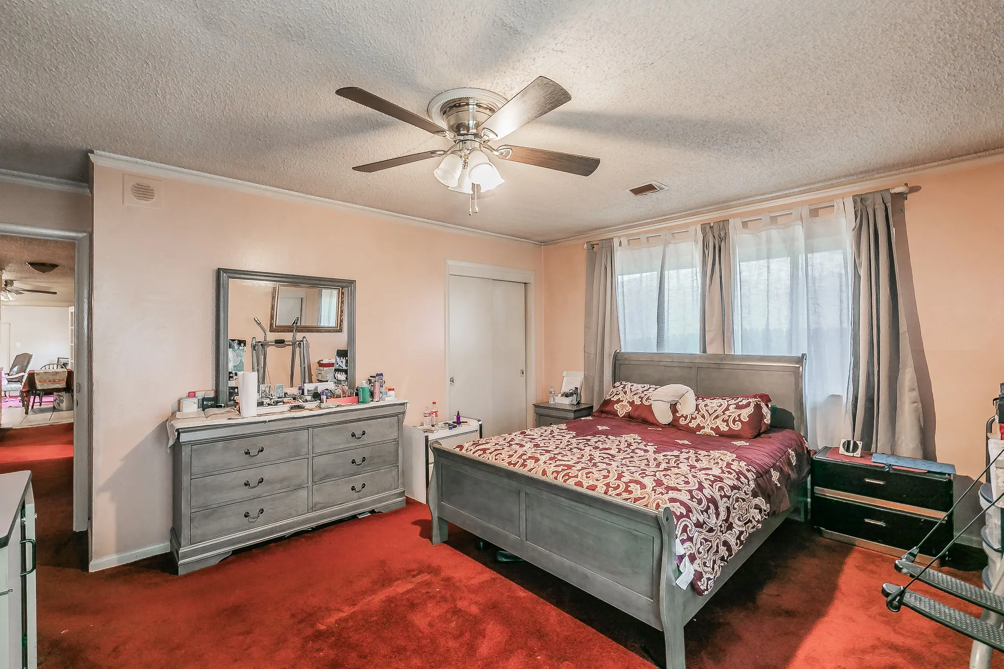 Carpeted bedroom featuring crown molding, a textured ceiling, ceiling fan, and a closet