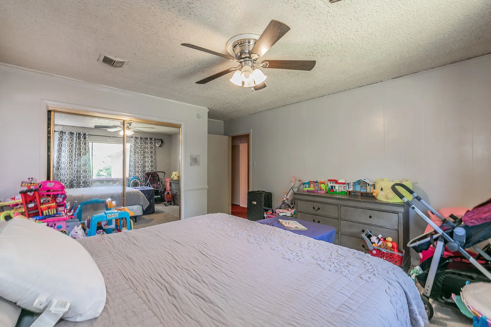 Bedroom with a textured ceiling, a ceiling fan, and crown molding