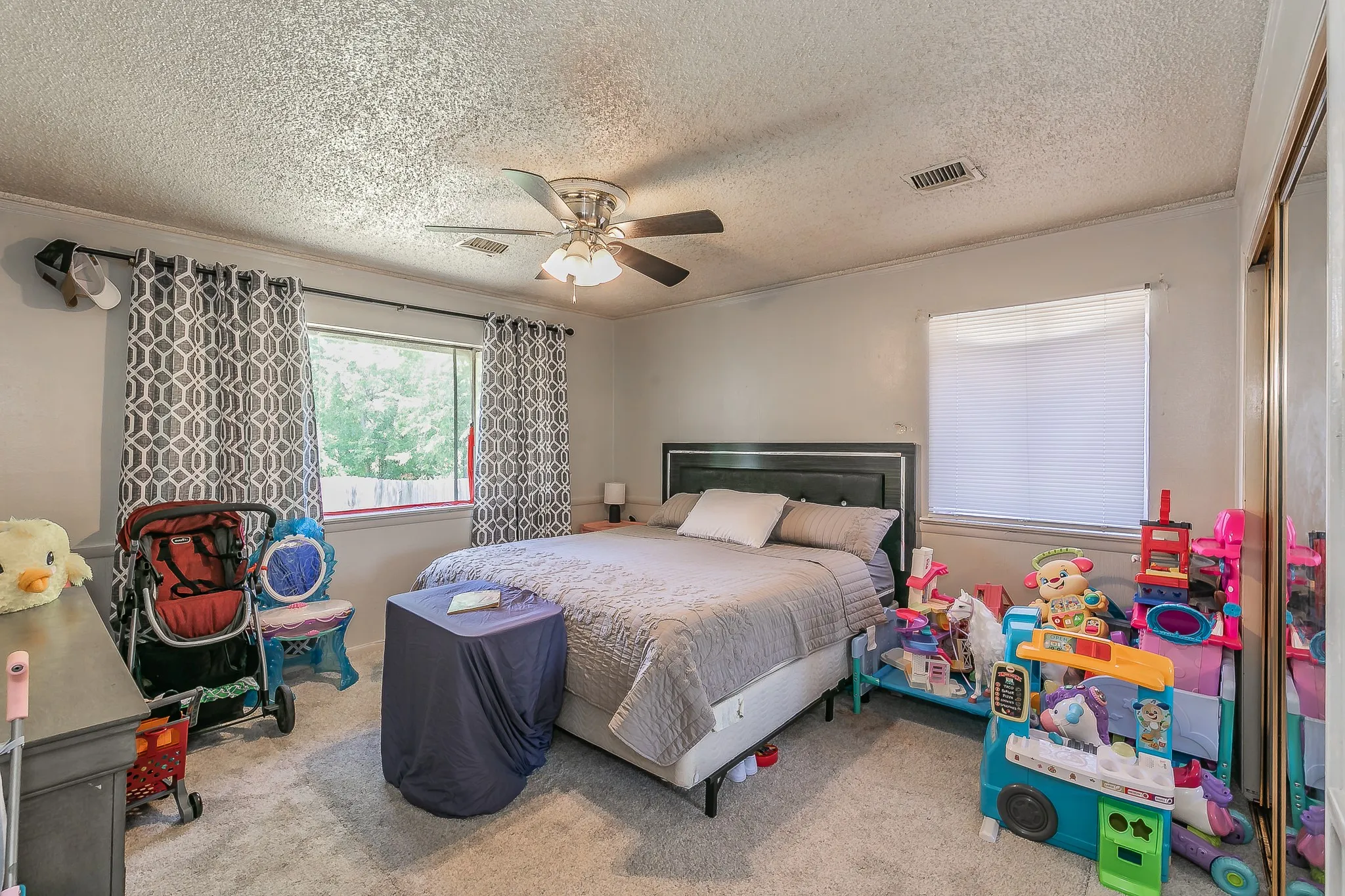 Bedroom featuring carpet floors, crown molding, a textured ceiling, and ceiling fan