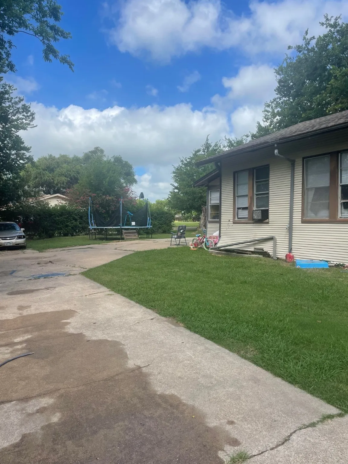 View of grassy yard featuring driveway