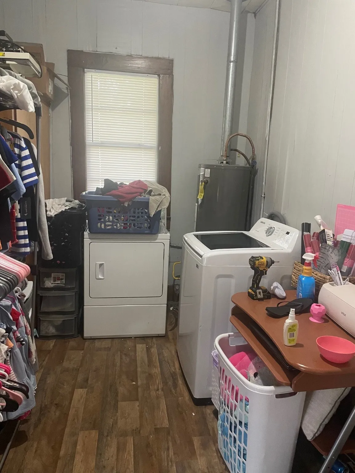 Laundry area featuring independent washer and dryer, wooden walls, wood finished floors, and water heater