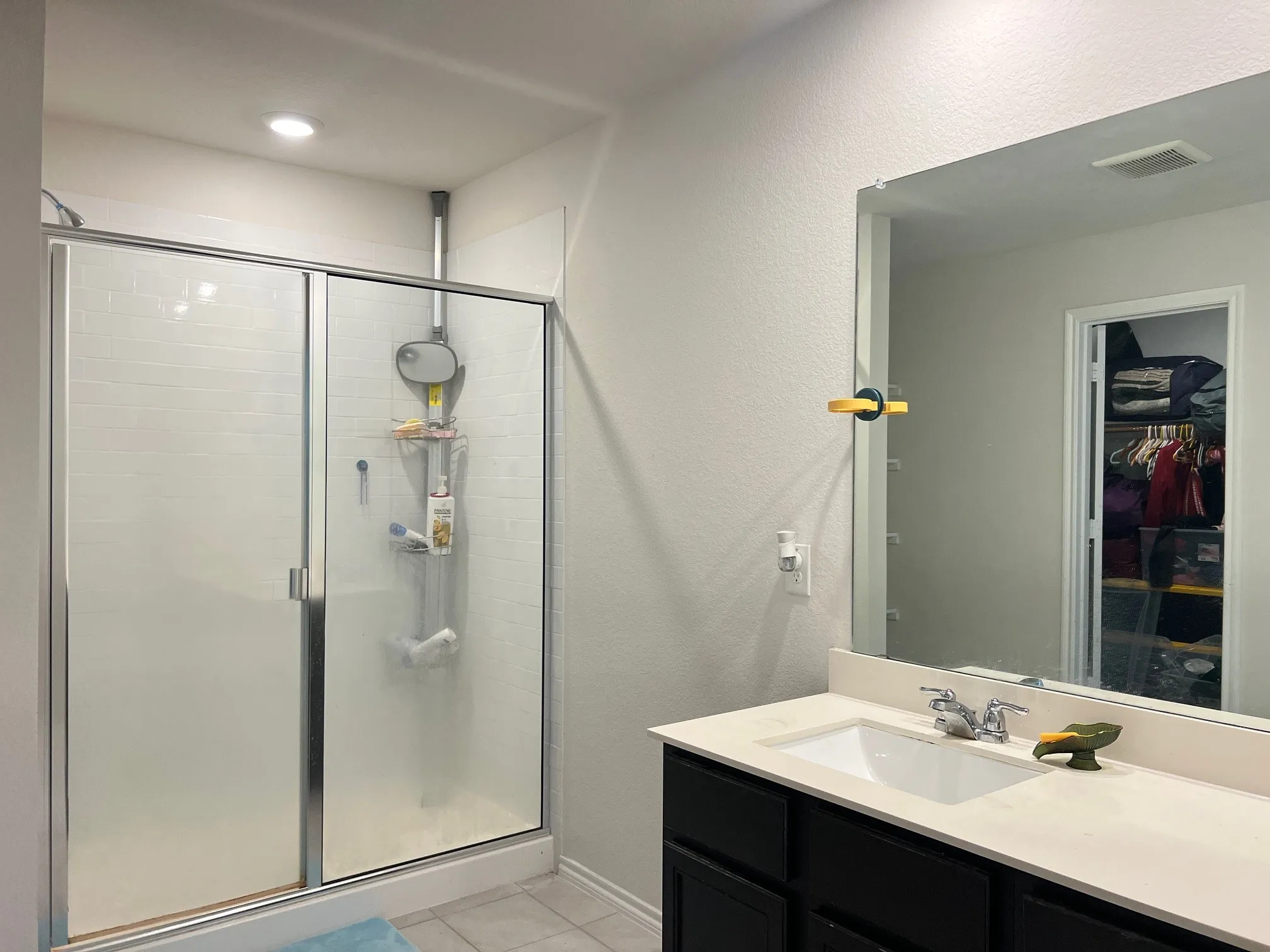 Full bathroom with a stall shower, a spacious closet, vanity, tile patterned floors, and a textured wall