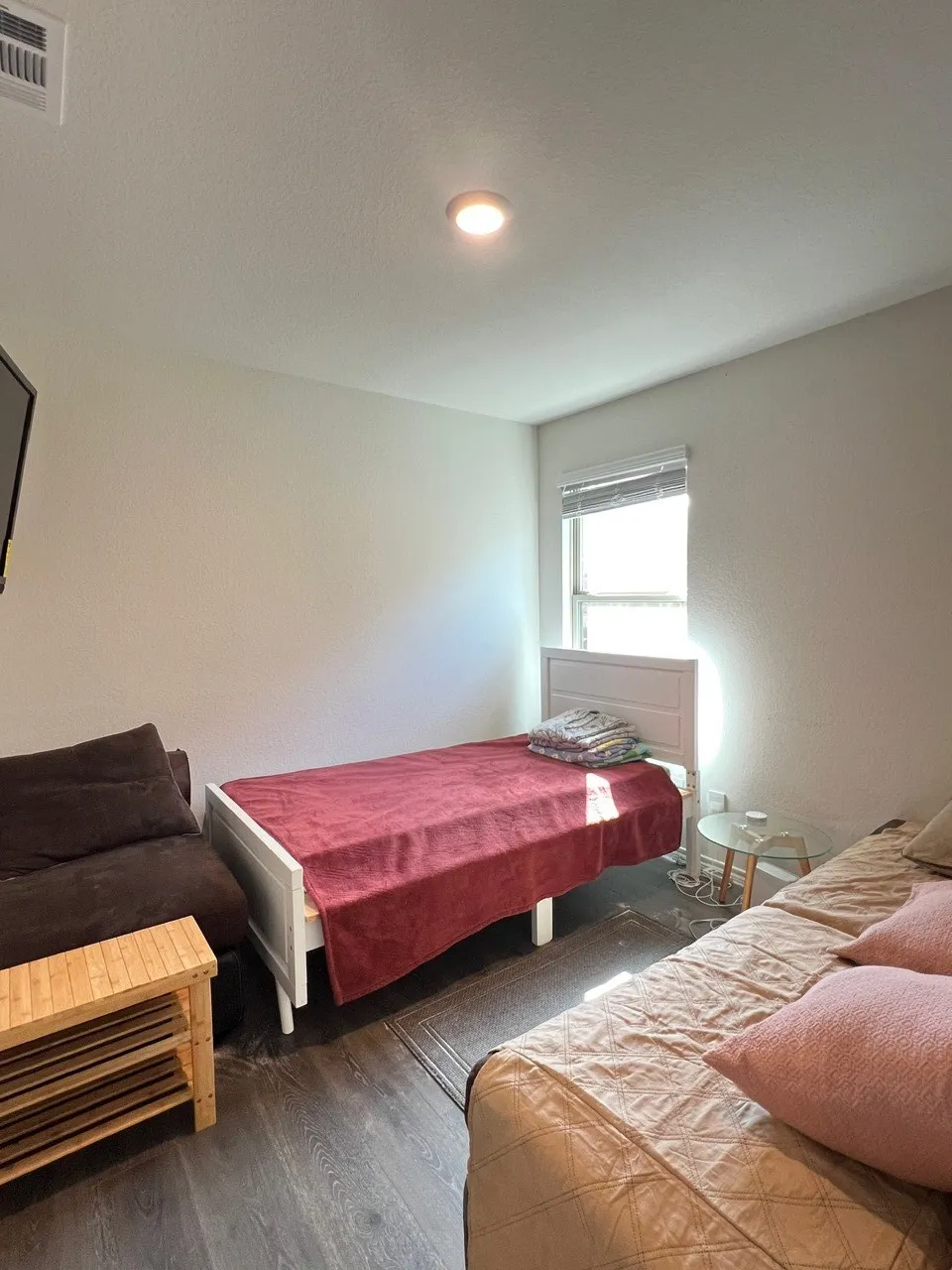 Bedroom featuring wood finished floors, a textured wall, and a textured ceiling