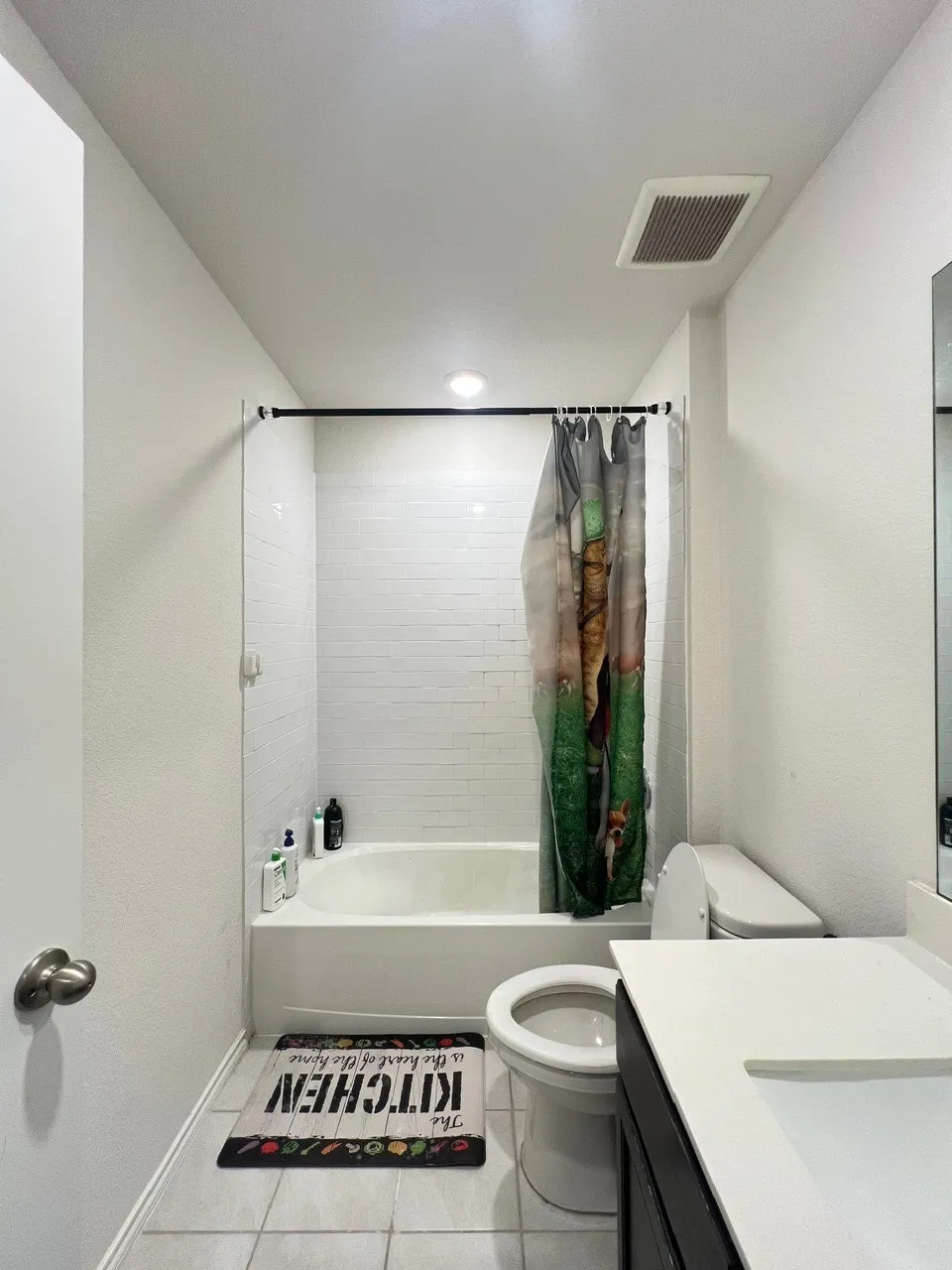Bathroom with vanity, shower / bathtub combination with curtain, and tile patterned floors