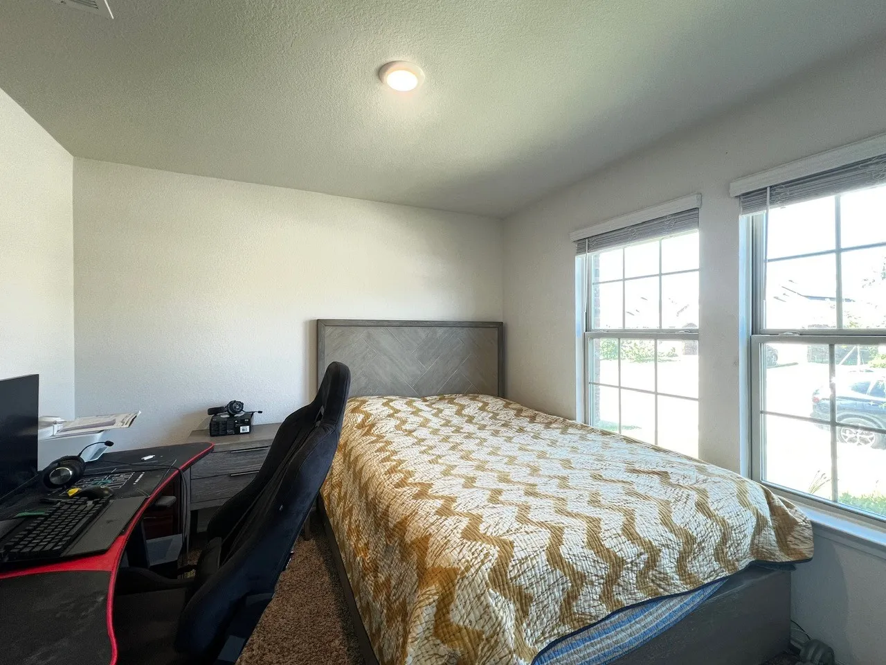 Carpeted bedroom featuring a textured ceiling and an office area