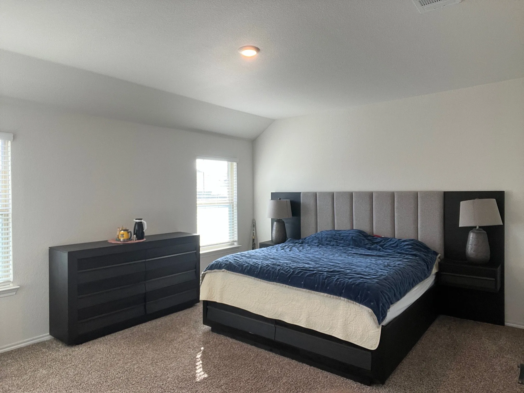 Carpeted bedroom with vaulted ceiling and baseboards