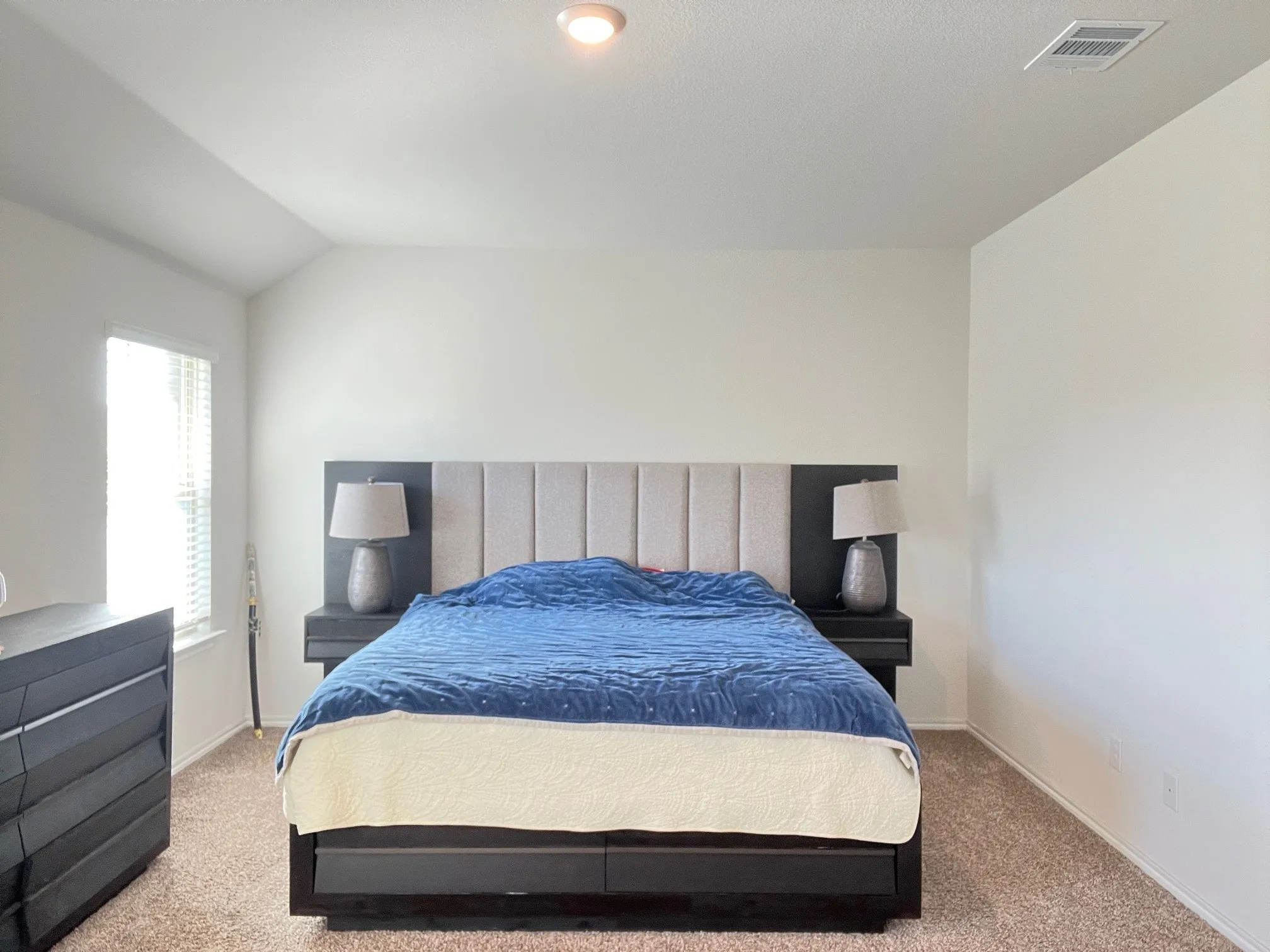 Carpeted bedroom with baseboards and vaulted ceiling