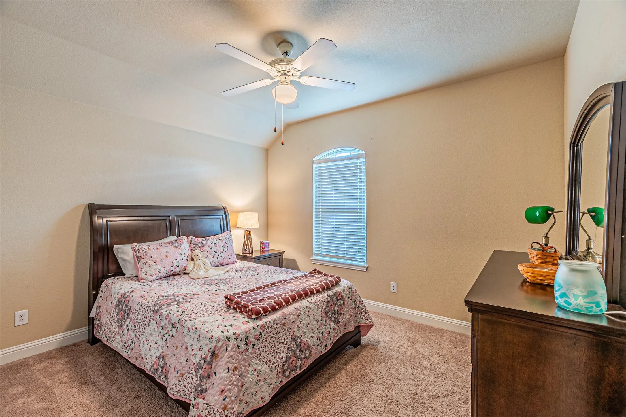 Bedroom with light carpet, lofted ceiling, and a ceiling fan