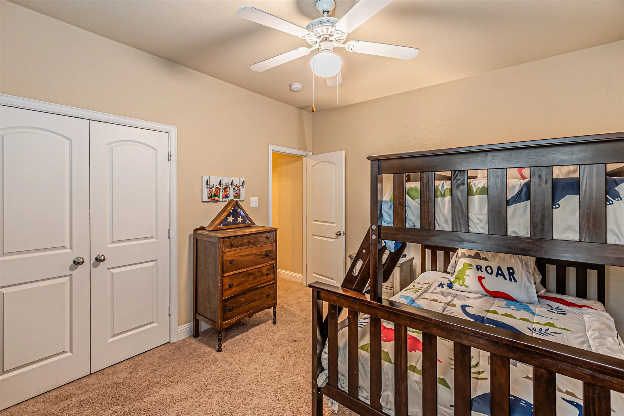Bedroom featuring light colored carpet, a closet, and a ceiling fan