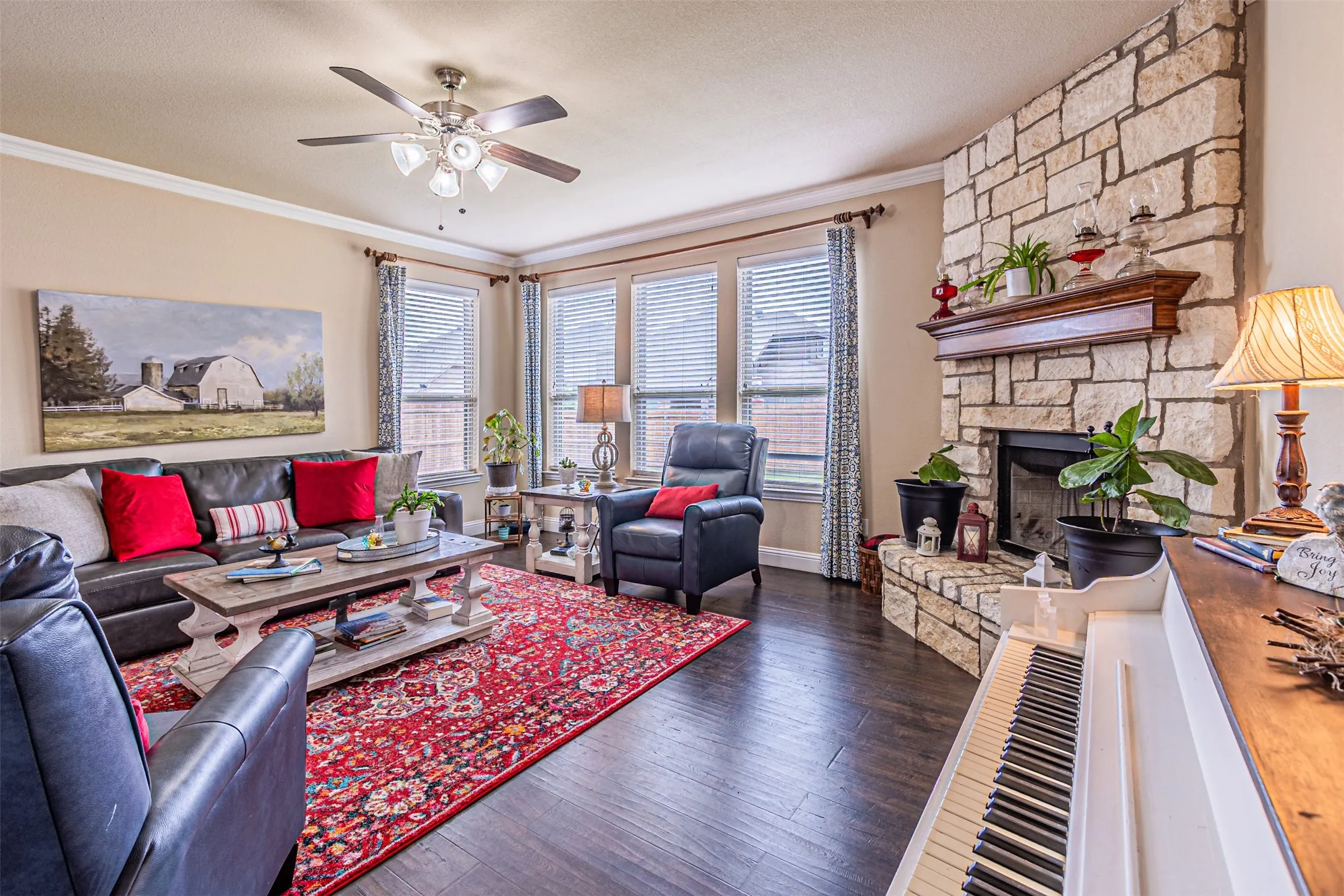 Living area with healthy amount of natural light, wood finished floors, ceiling fan, ornamental molding, and a textured ceiling