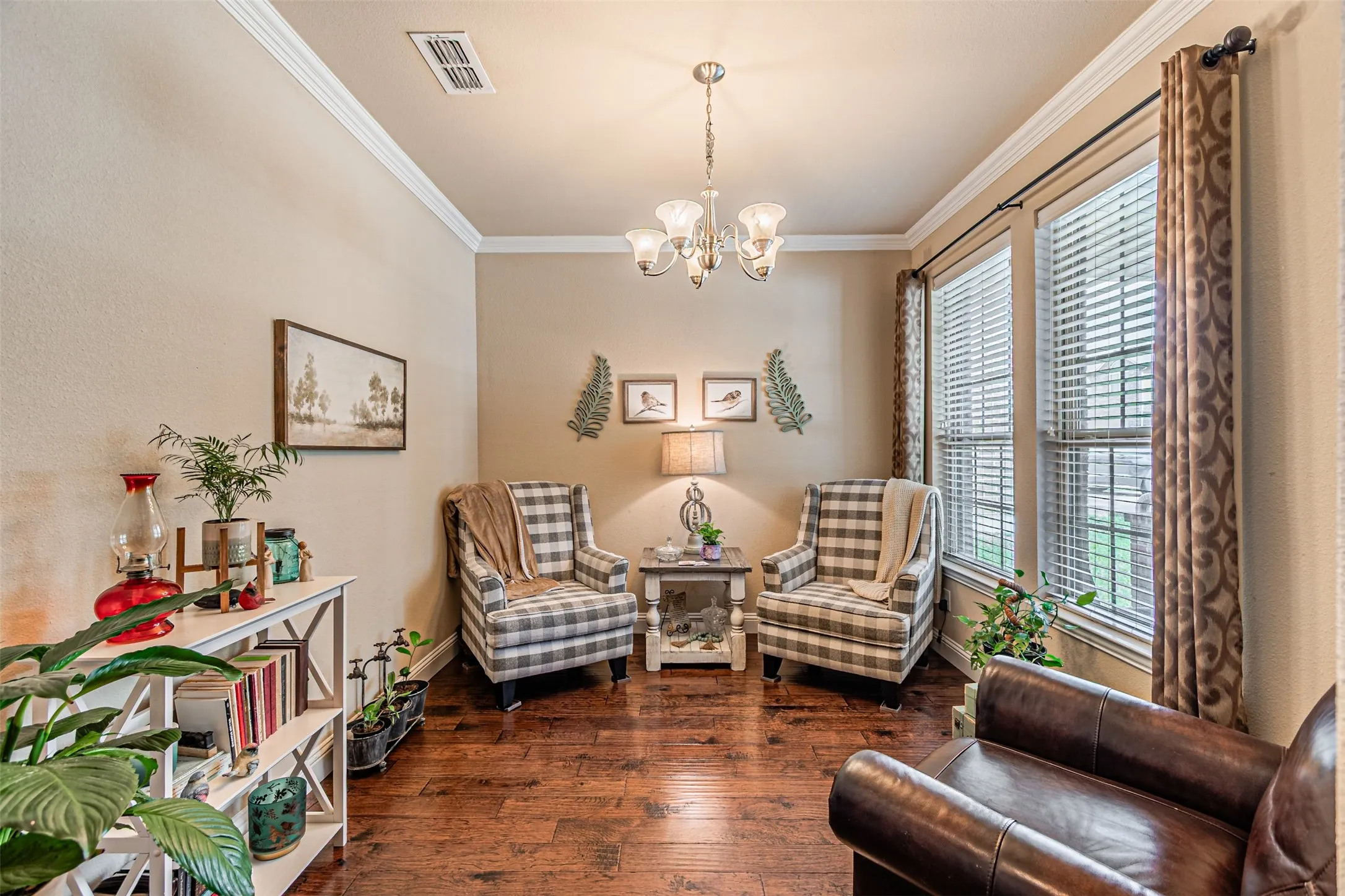 Sitting room featuring ornamental molding, wood-type flooring, and a chandelier
