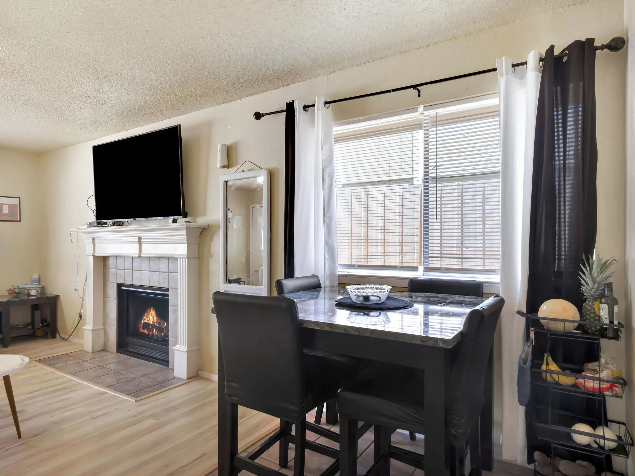 Dining space with a textured ceiling, wood finished floors, and a fireplace