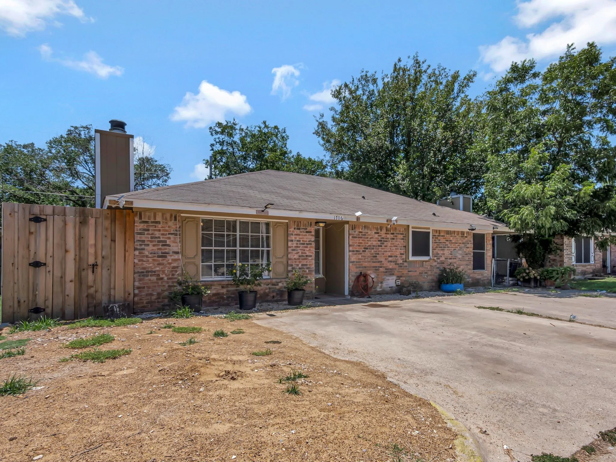 Ranch-style house with brick siding, a chimney, and a shingled roof