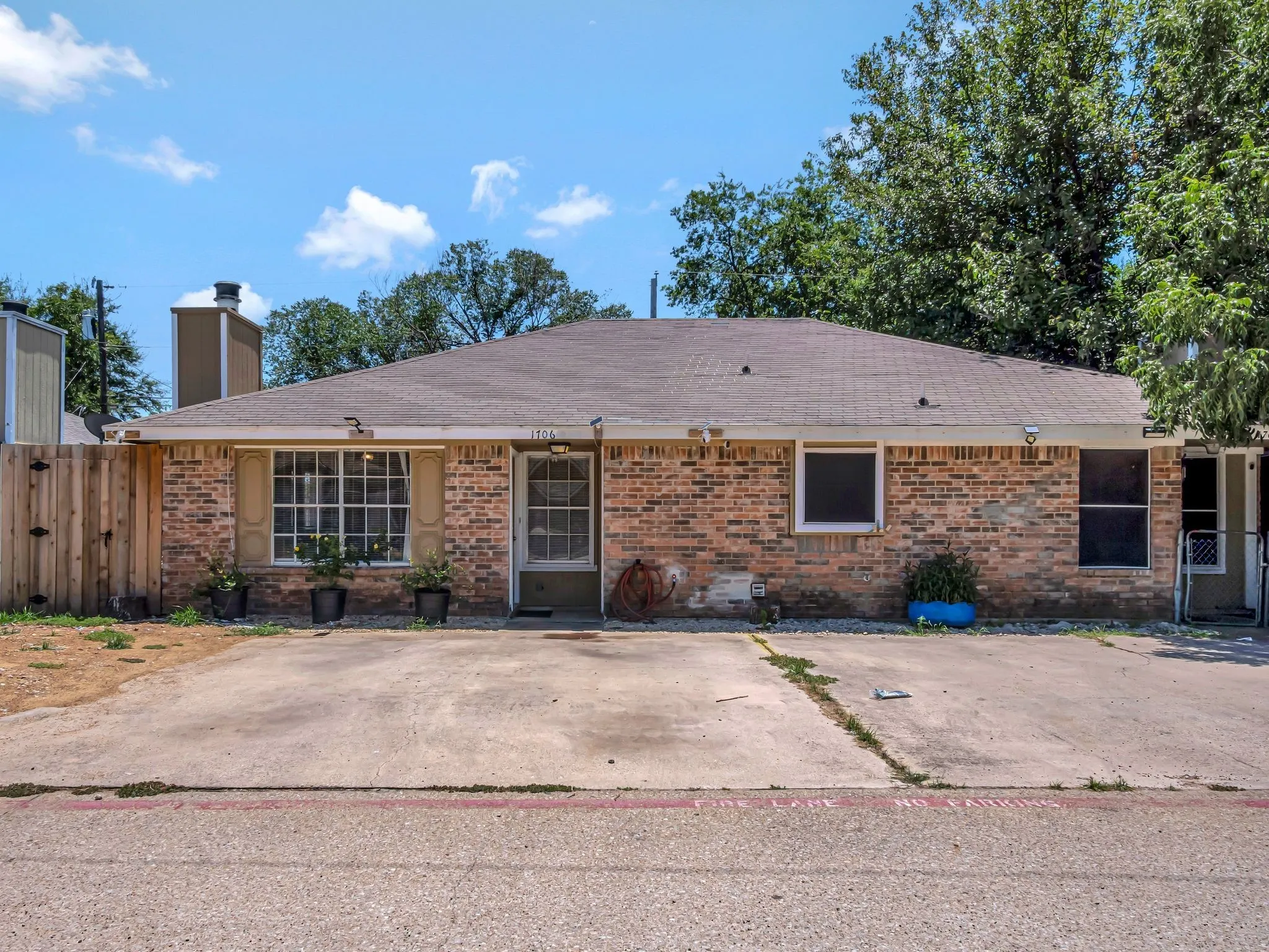 Single story home with brick siding, roof with shingles, and a chimney