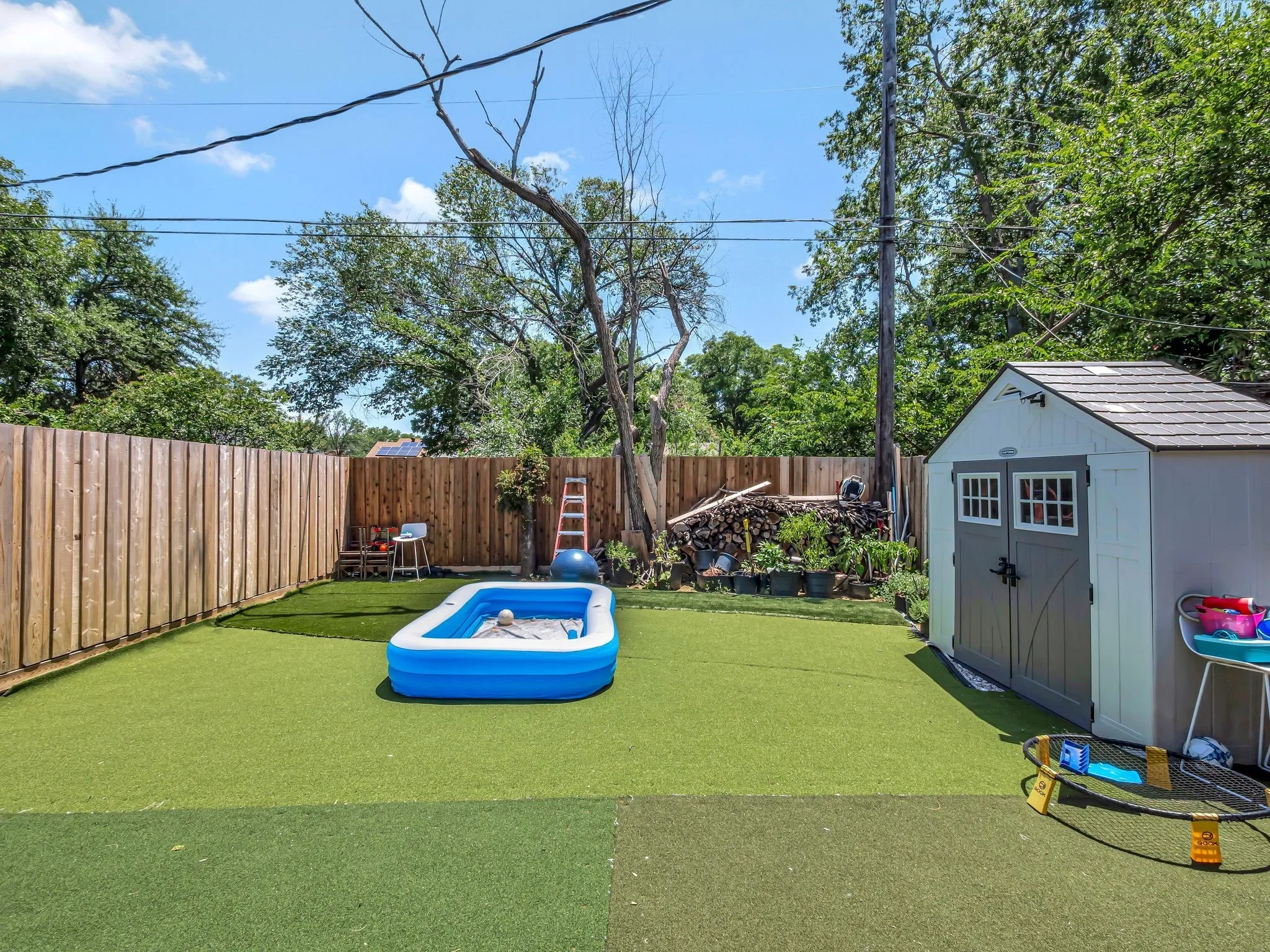 Fenced backyard featuring a storage shed