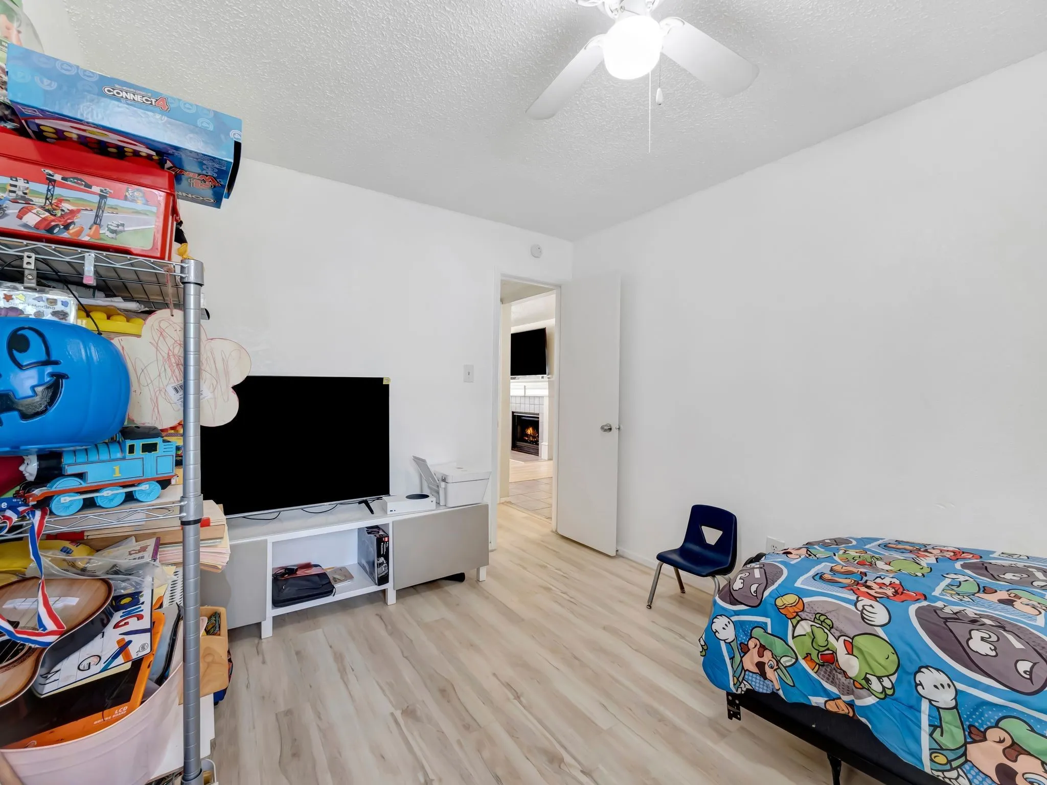 Bedroom featuring wood finished floors, a textured ceiling, and ceiling fan