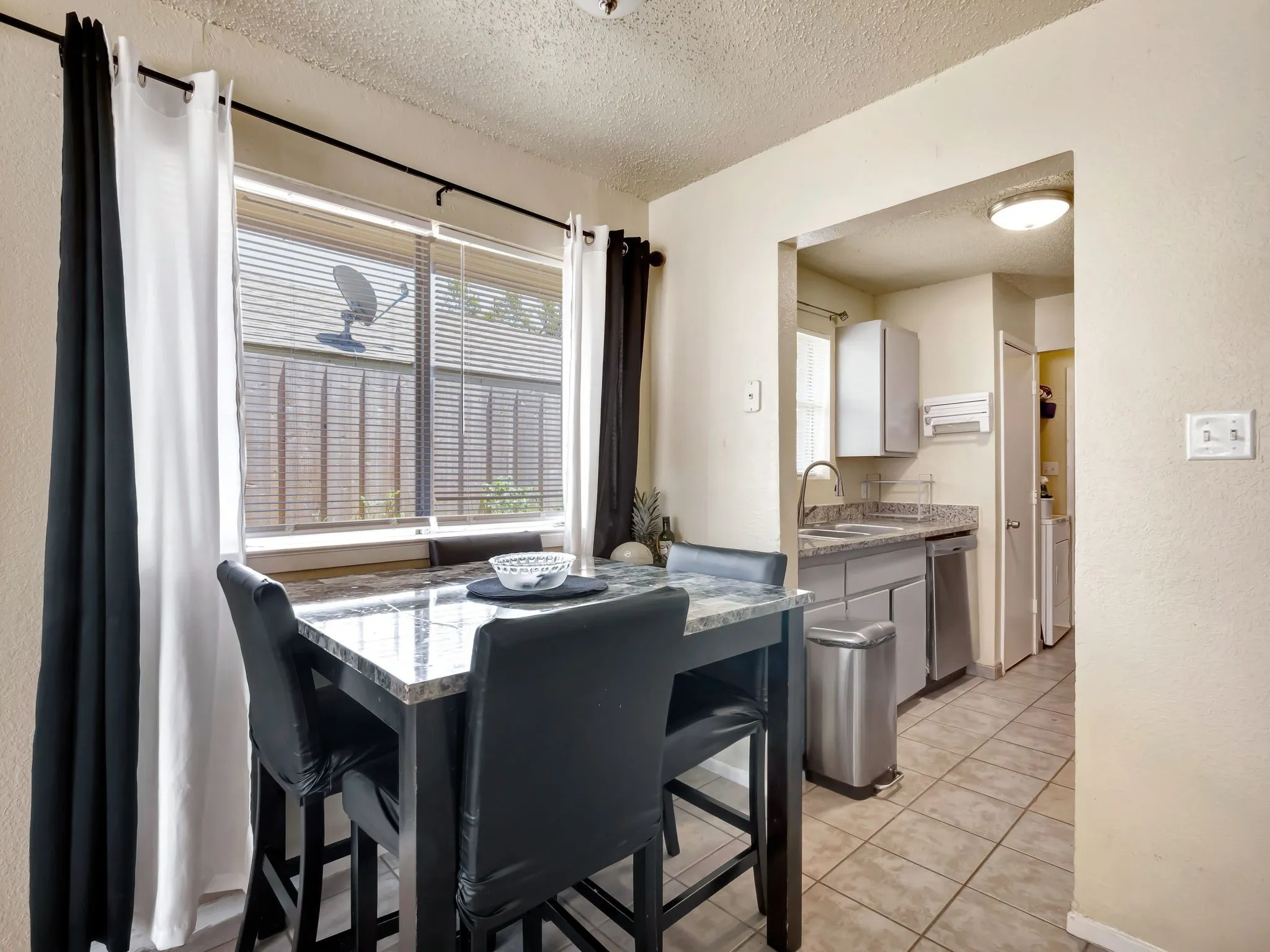 Dining area featuring a textured ceiling and light tile patterned floors